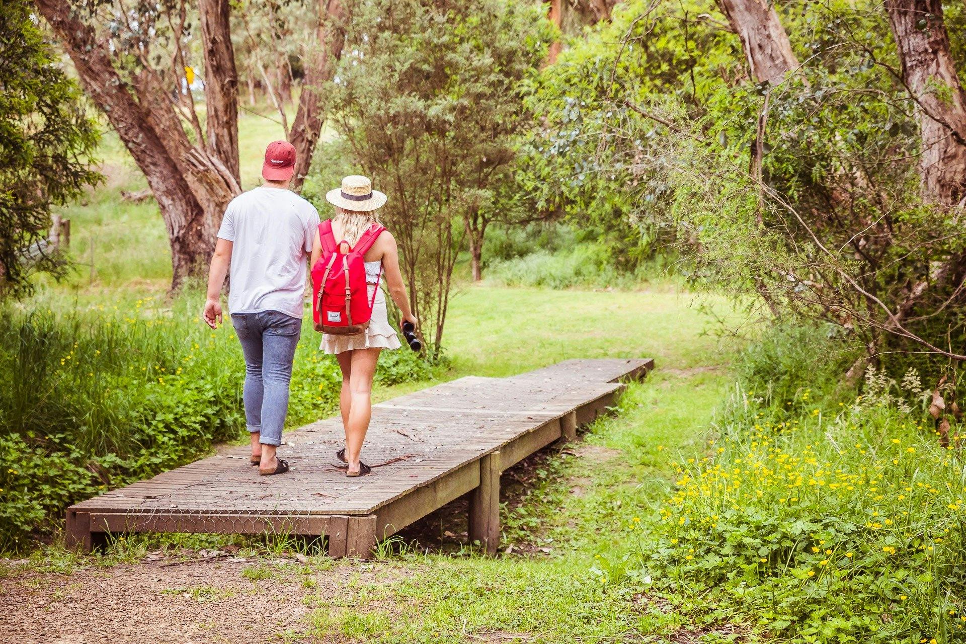 Couple walking over timber bridge
