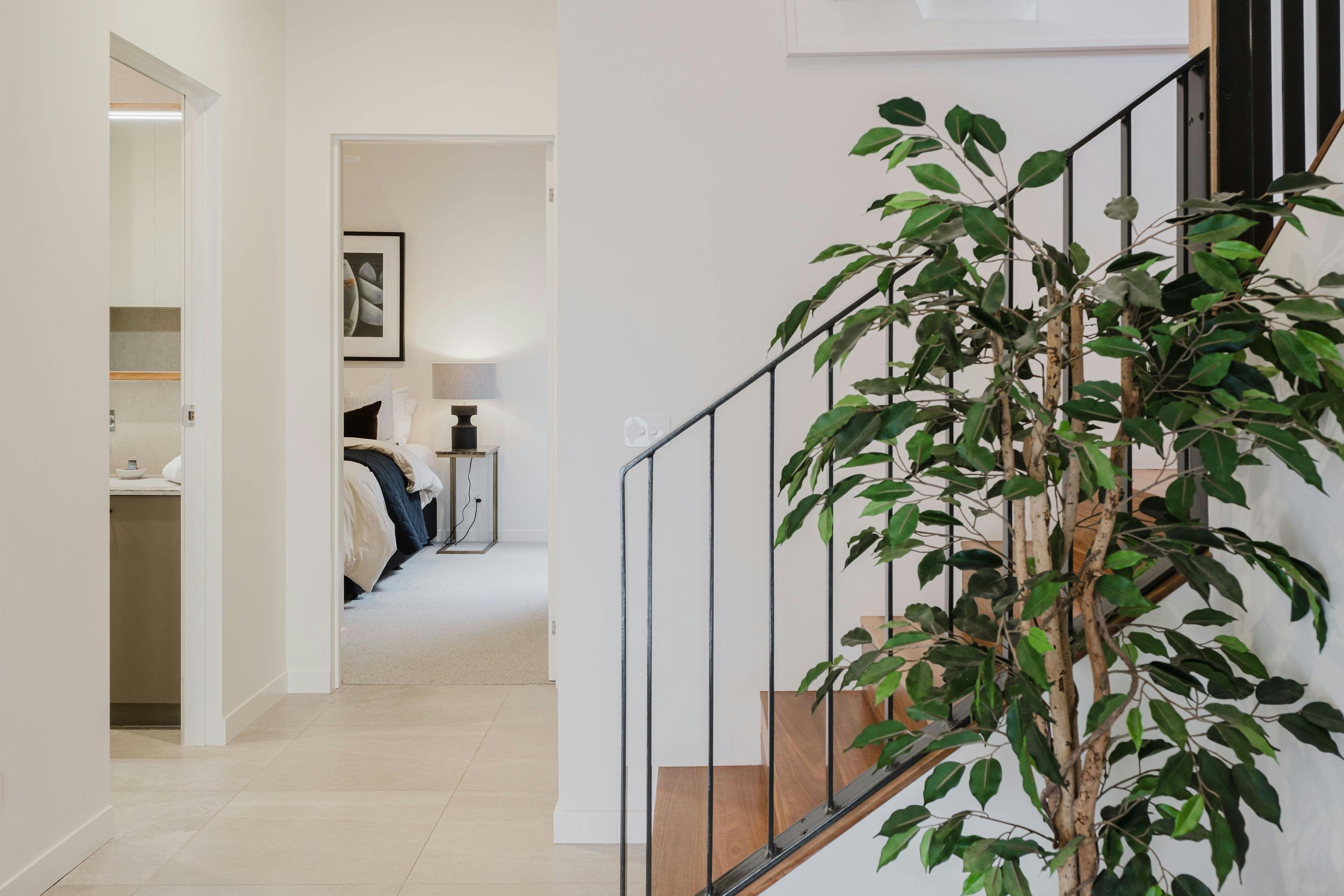 hallway with stairs and a plant next to it