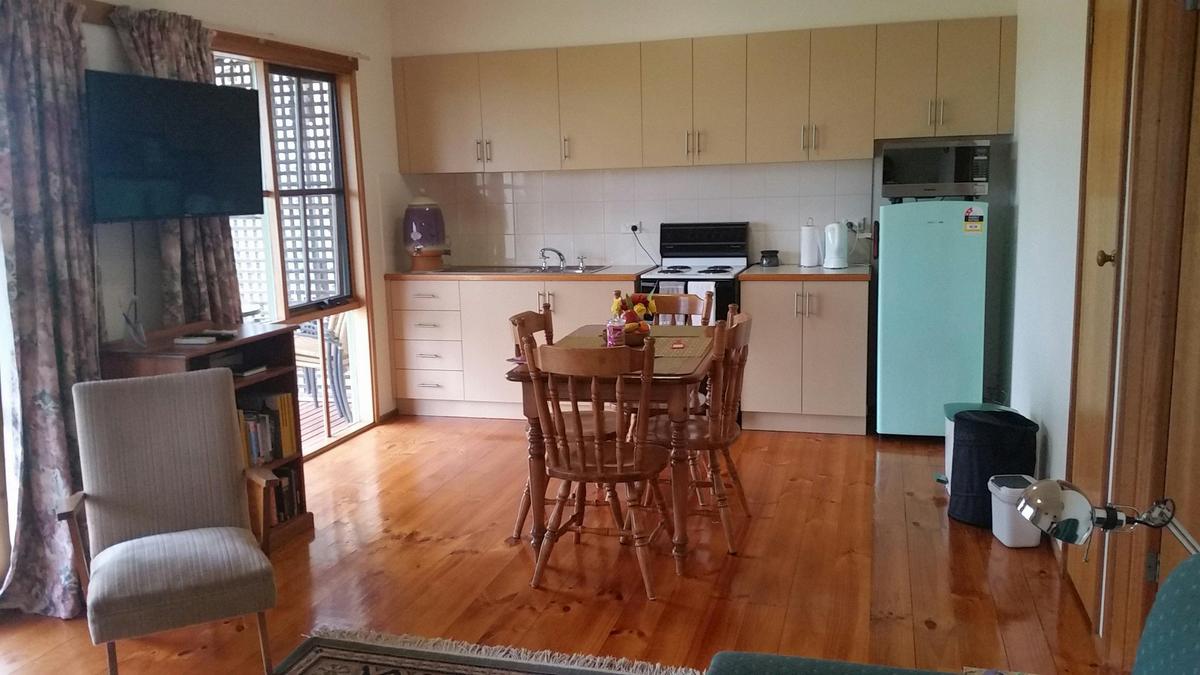 Fully equipped kitchen and living area with large-screen TV