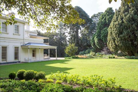 Como House surrounder by trees and a lawn