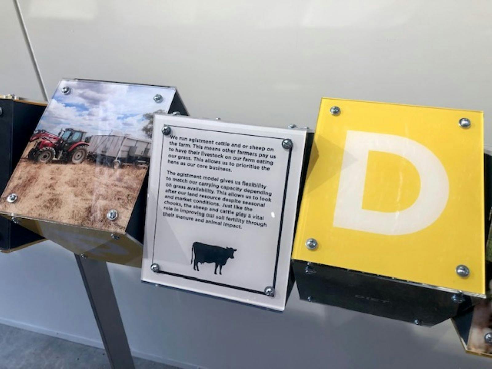 Close up of three interactive panels with pictures of the farm and information about their eggs