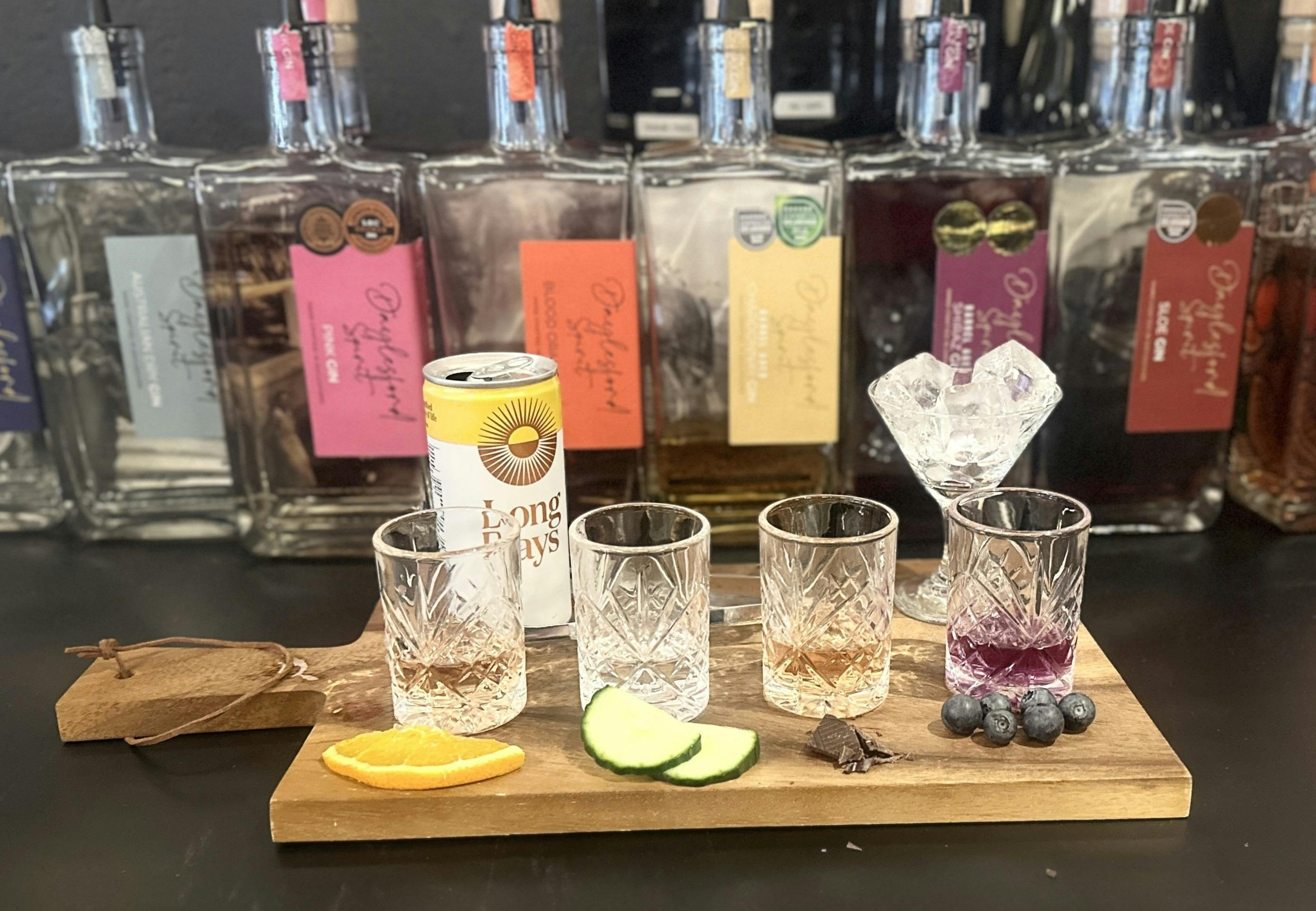 A Gin flight with bottles of gin behind