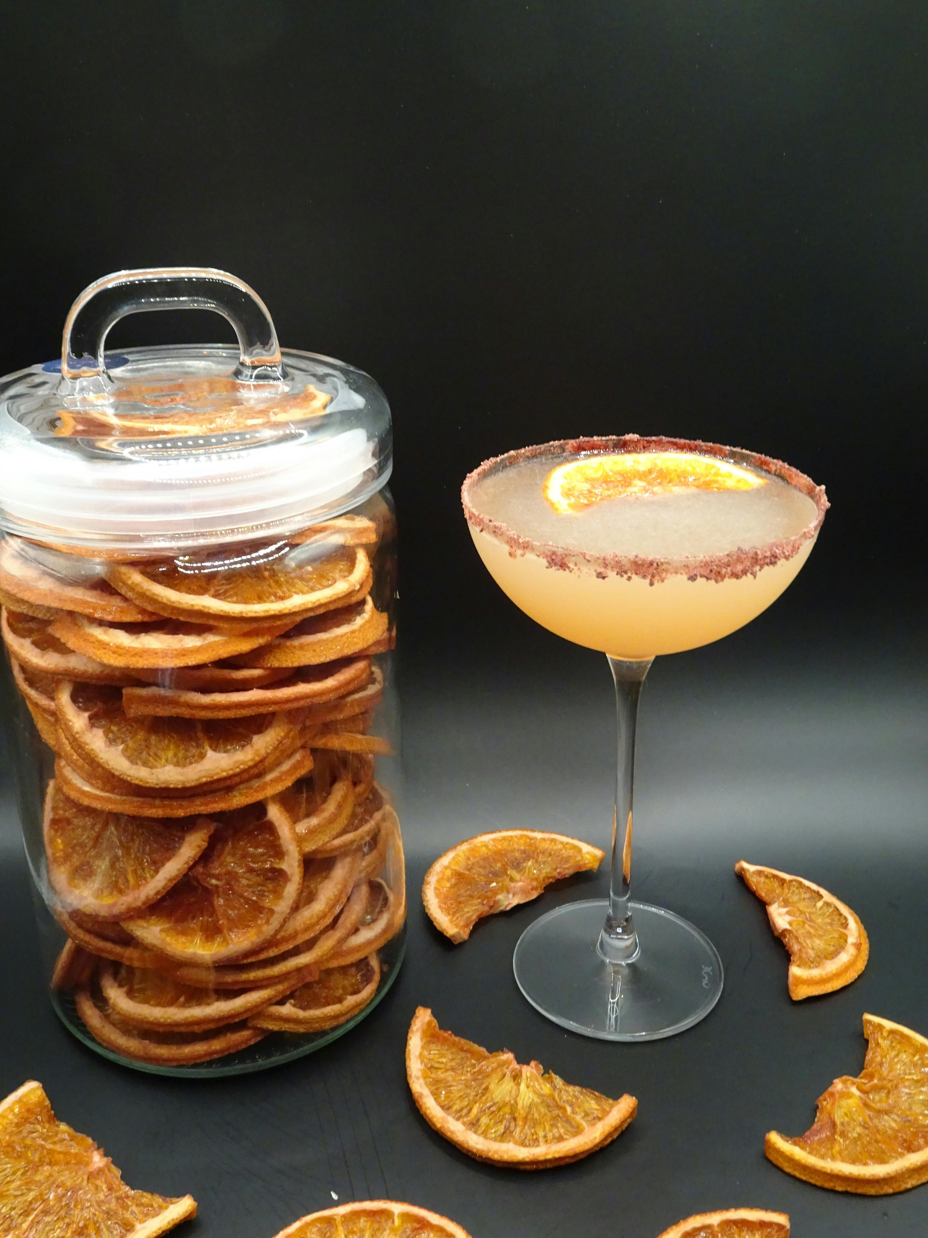 Cocktail next to a jar of dehydrated oranges