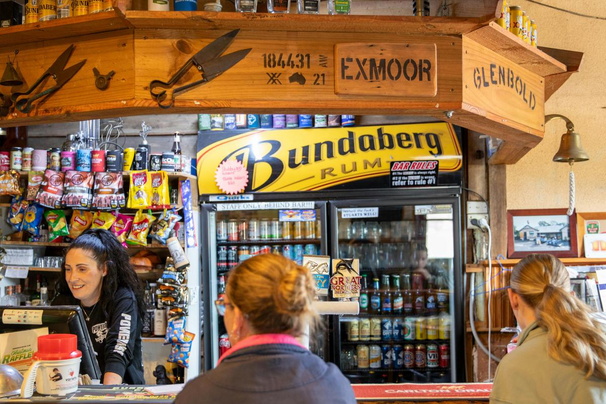 Bar area with drinks on a shelf and in a fridge in a pub