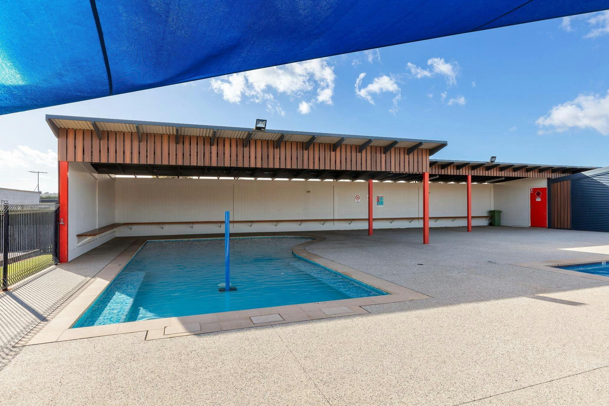 Shaded kids’ pool area with seating at Collendina Holiday Park on a sunny day