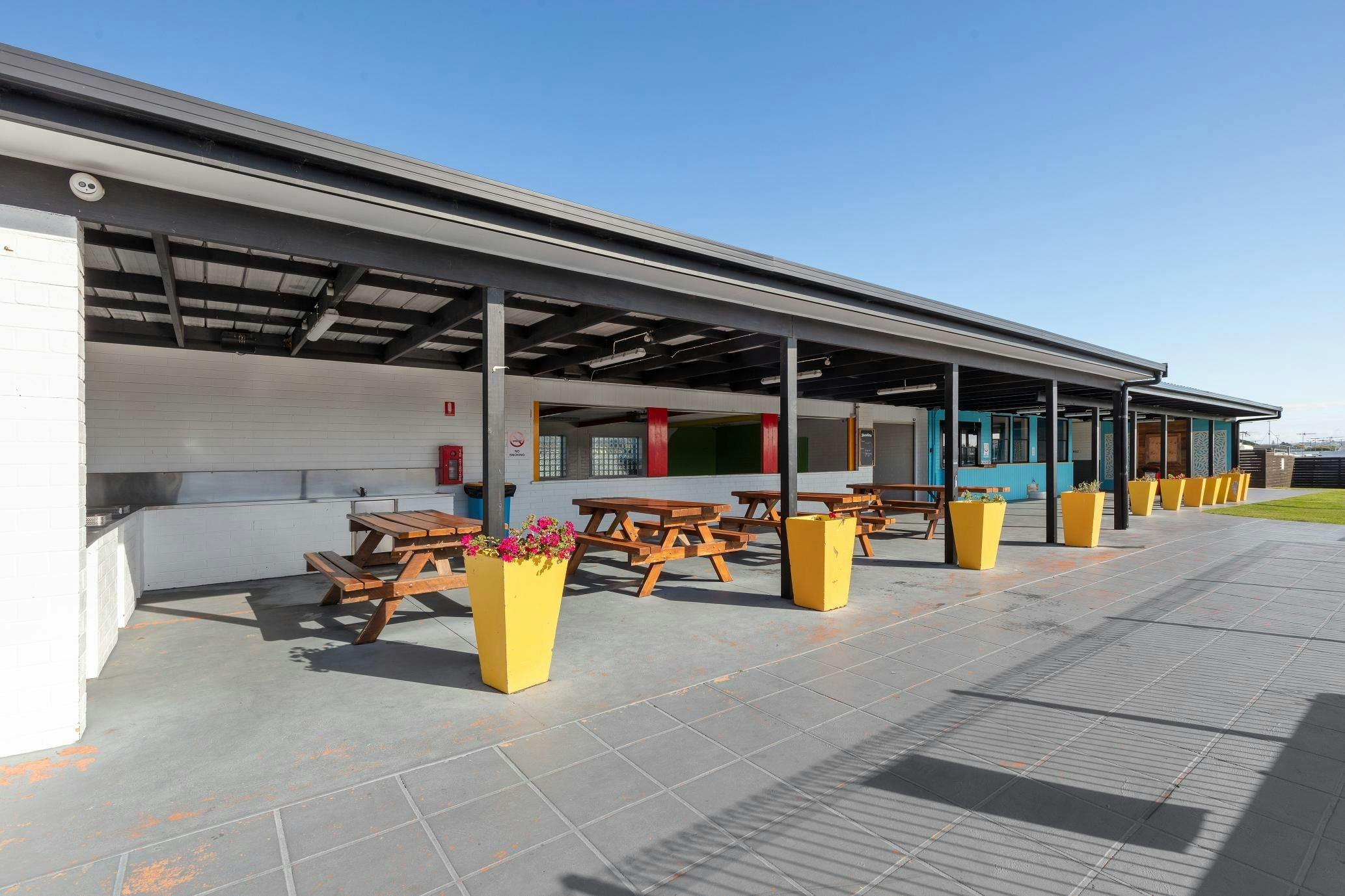 Outdoor BBQ and camp kitchen area with picnic tables at Collendina Holiday Park.