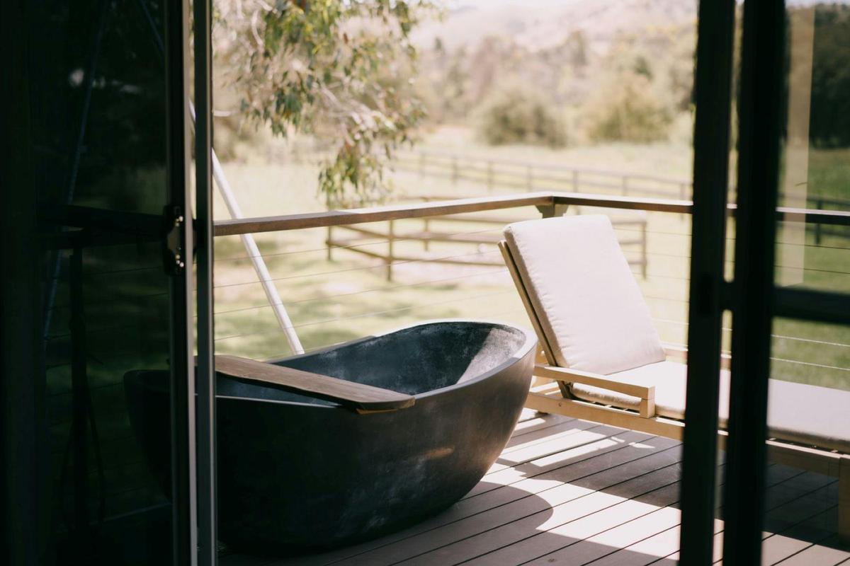 An outdoor stone bath, overlooking the countryside