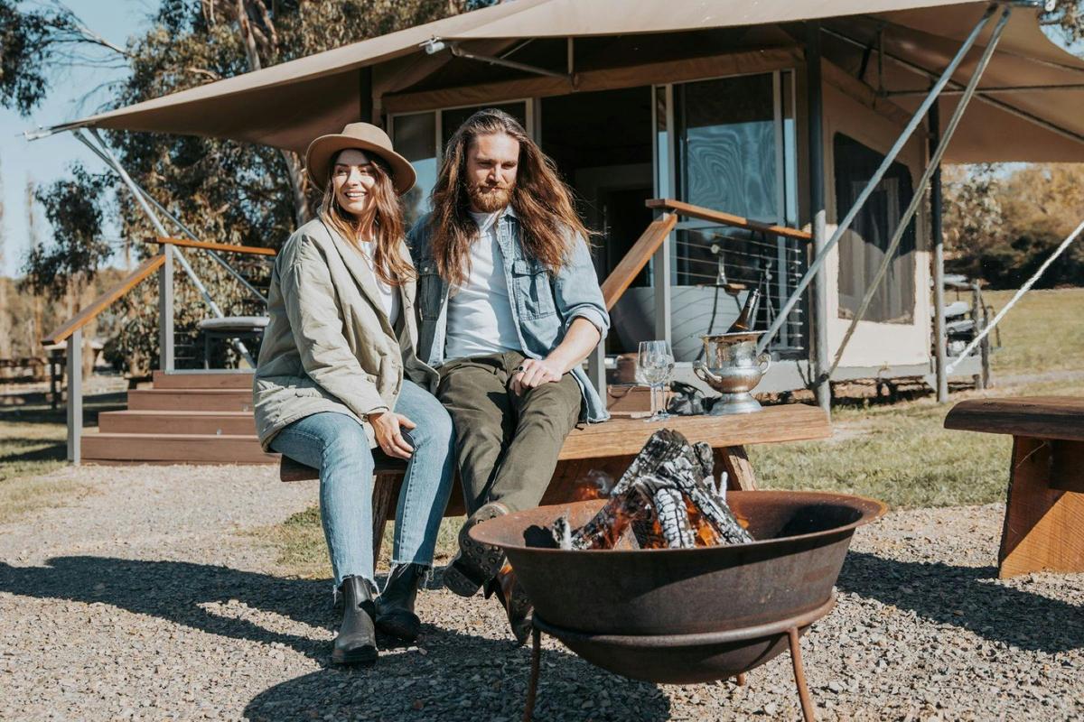 Enjoying an afternoon by the open fire pit in front of an eco glamping tent