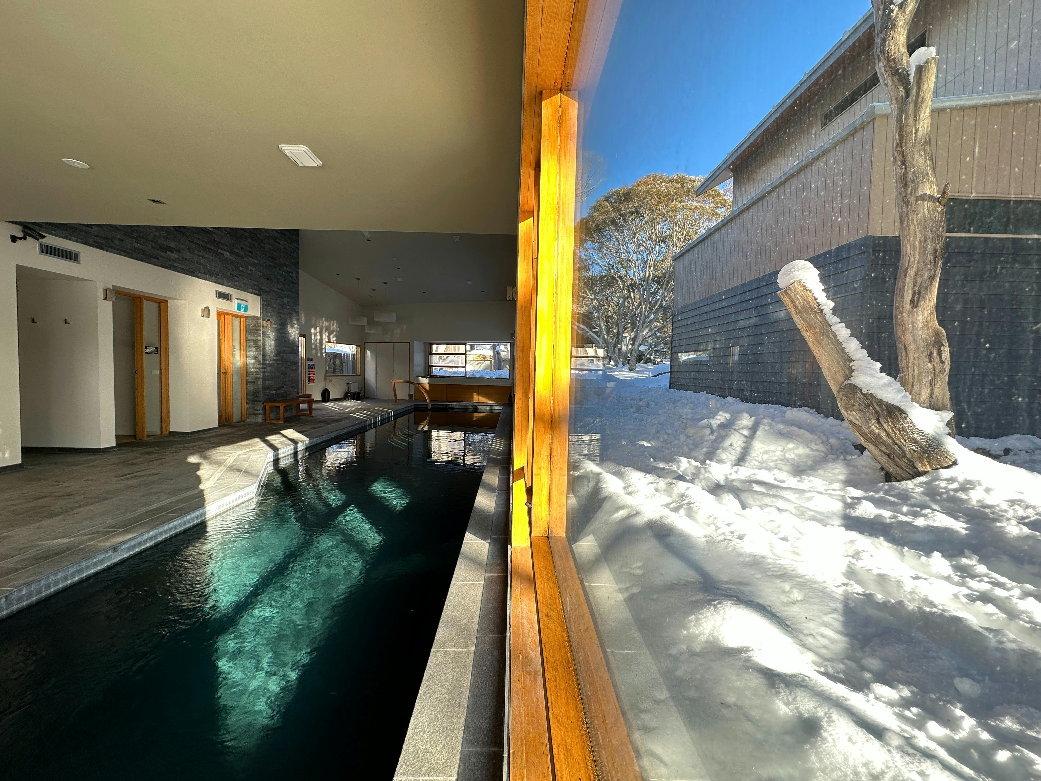 Indoor Lap Pool facing a window looking out onto snow