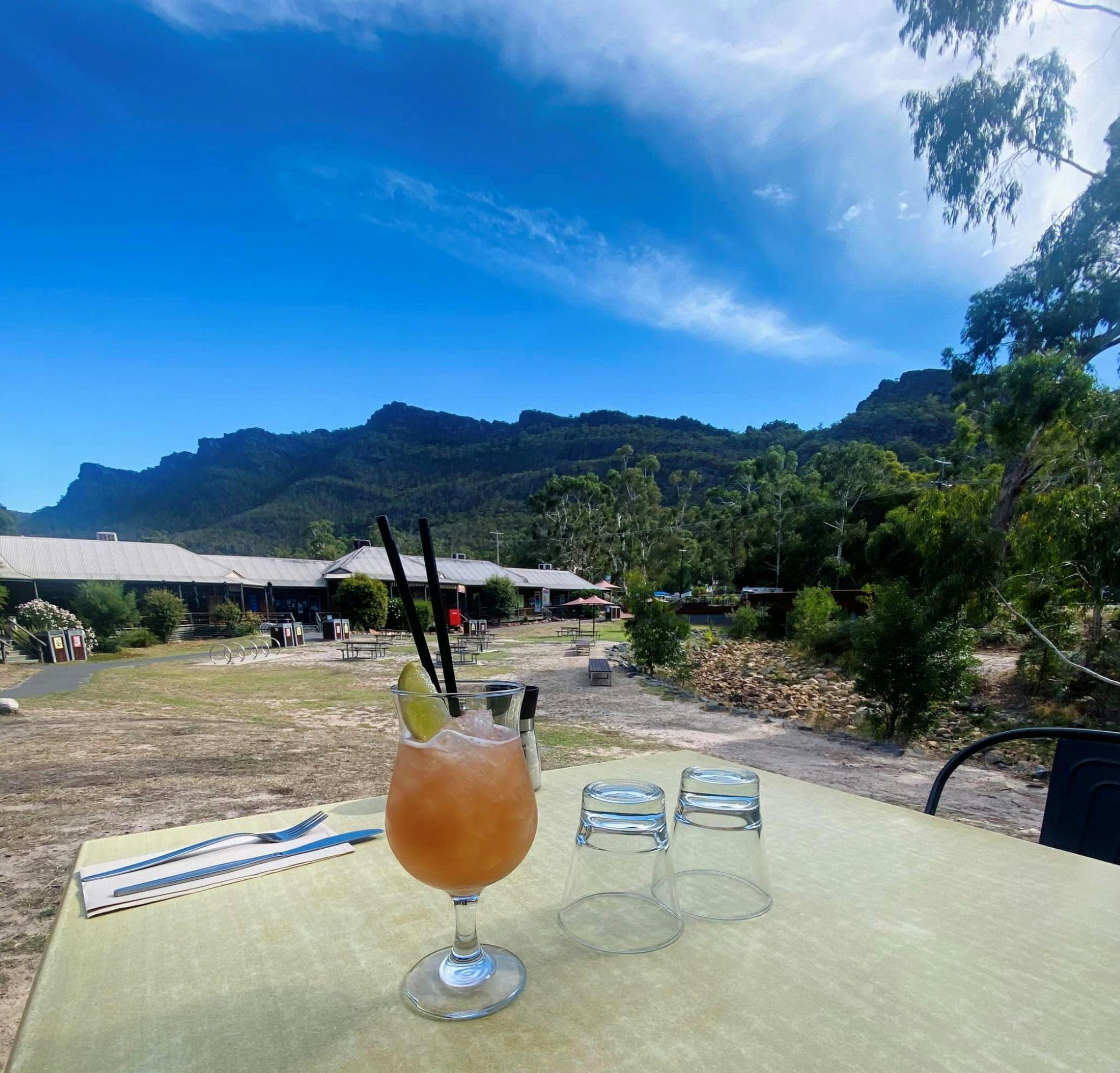 Cocktail on an outdoor table with a mountain in the background