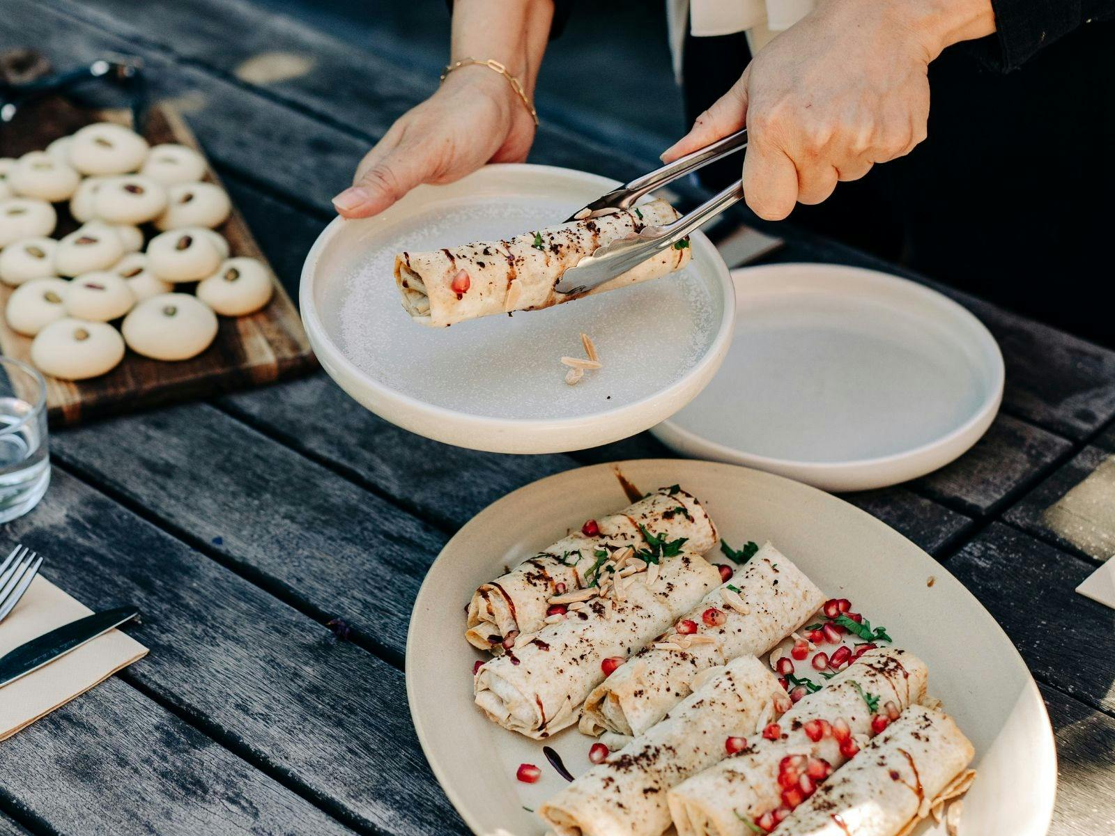 Person serving rolls onto plate