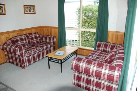 Two red and white checkered couches in a room with a large window