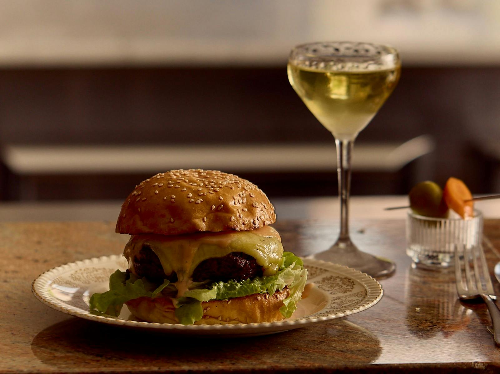 A juicy cheeseburger, cooked over fire + the House martini