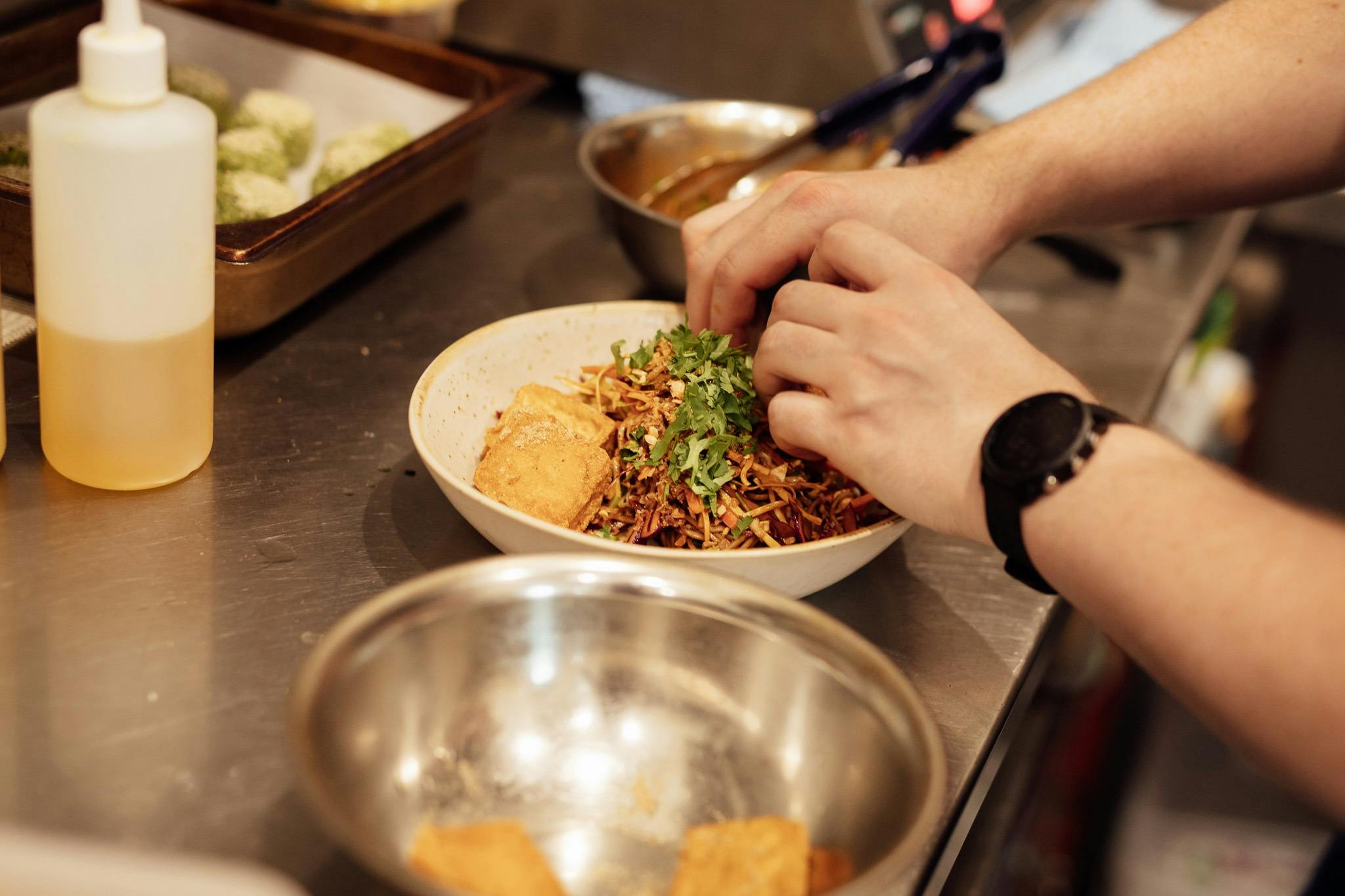 The chef preparing the Falafel bowl