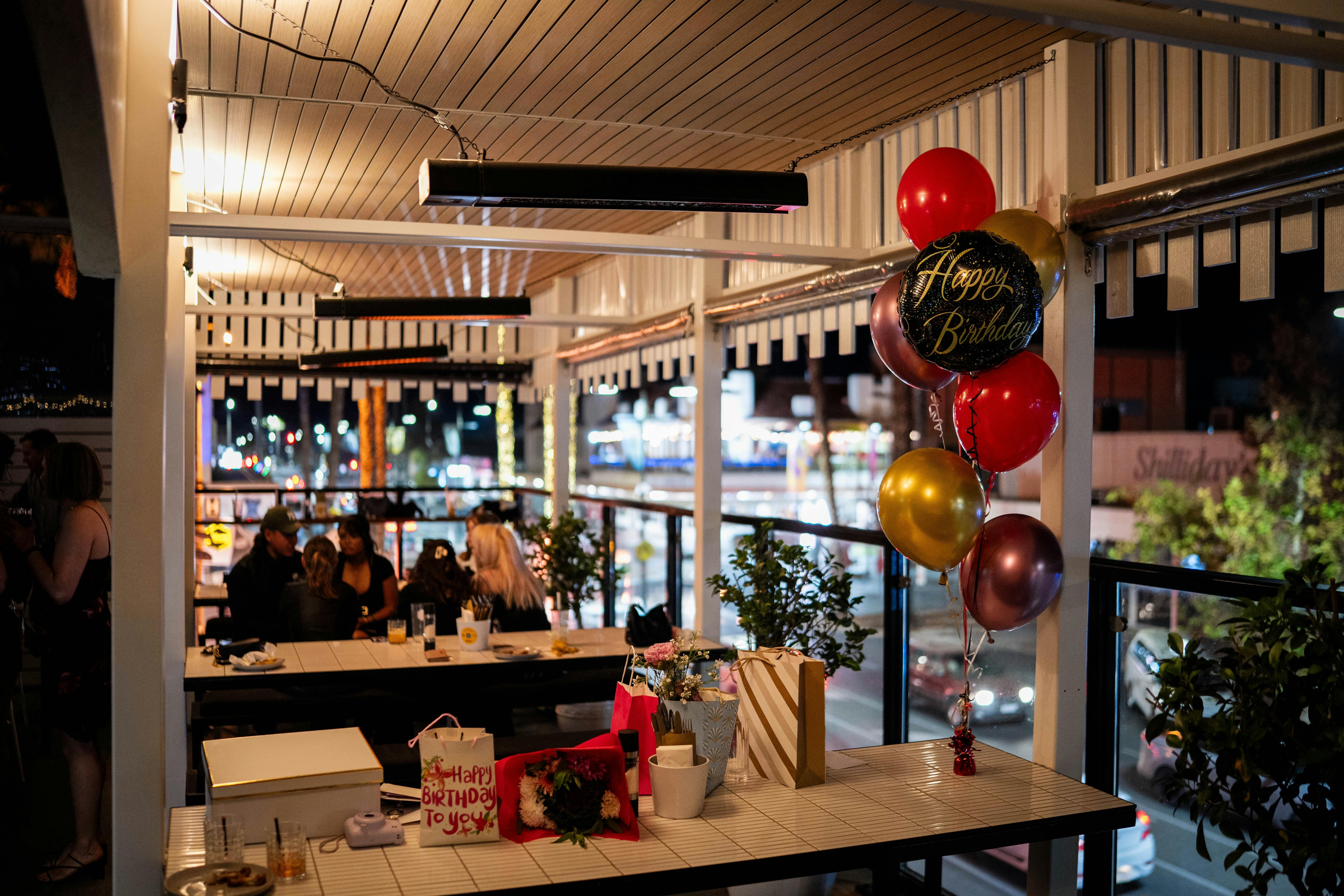 Honey Bar outdoor dining space and balloons on a table celebrating a birthday