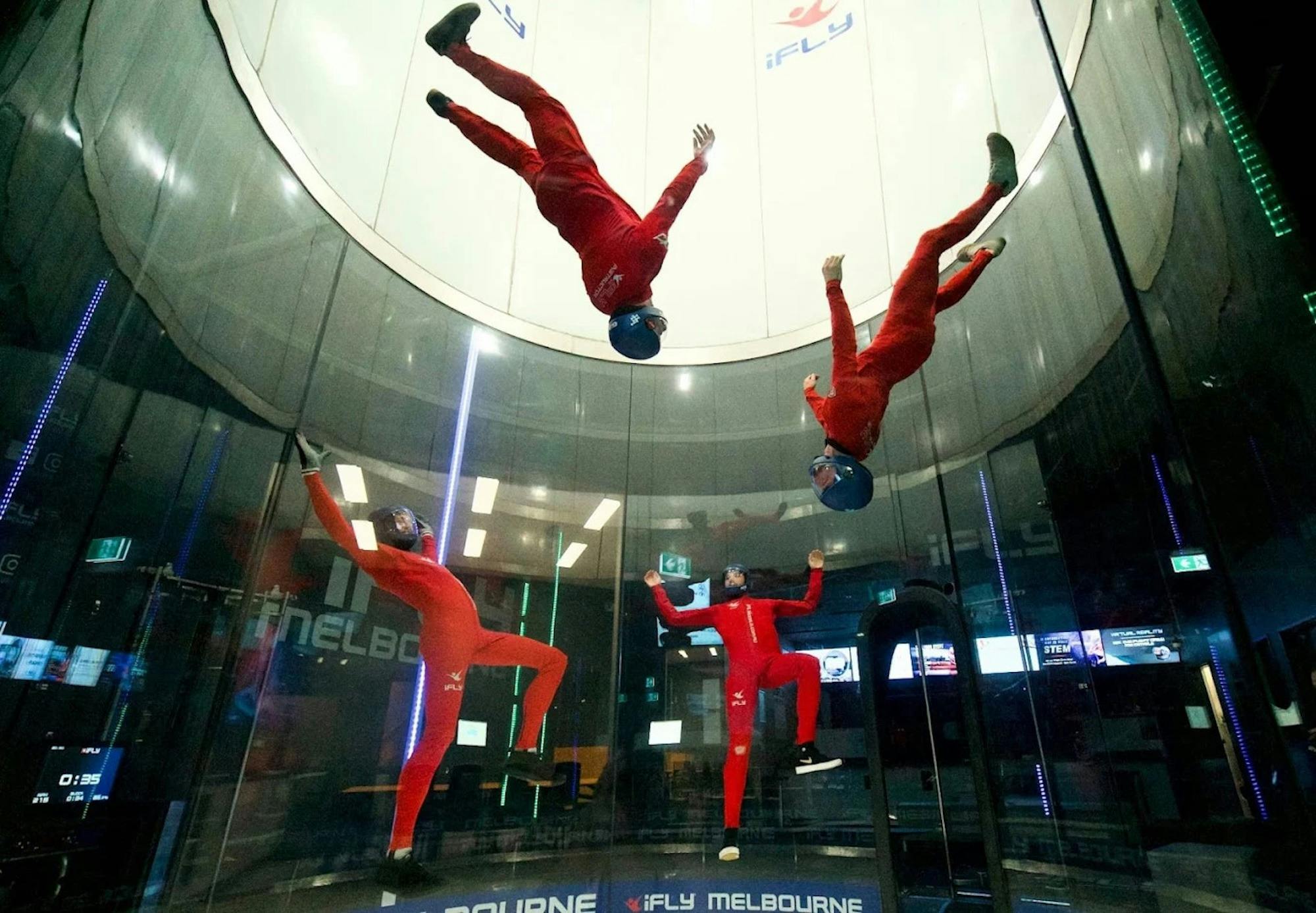 Group of instructors performing a formation inside the iFLY Melbourne wind tunnel.