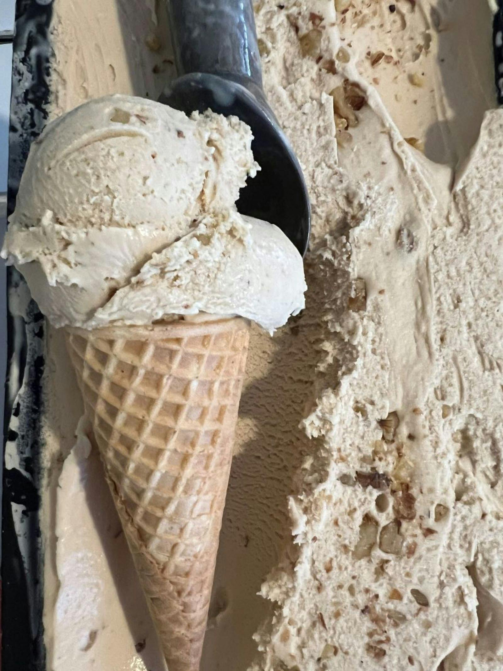 Light brown ice cream in a cone