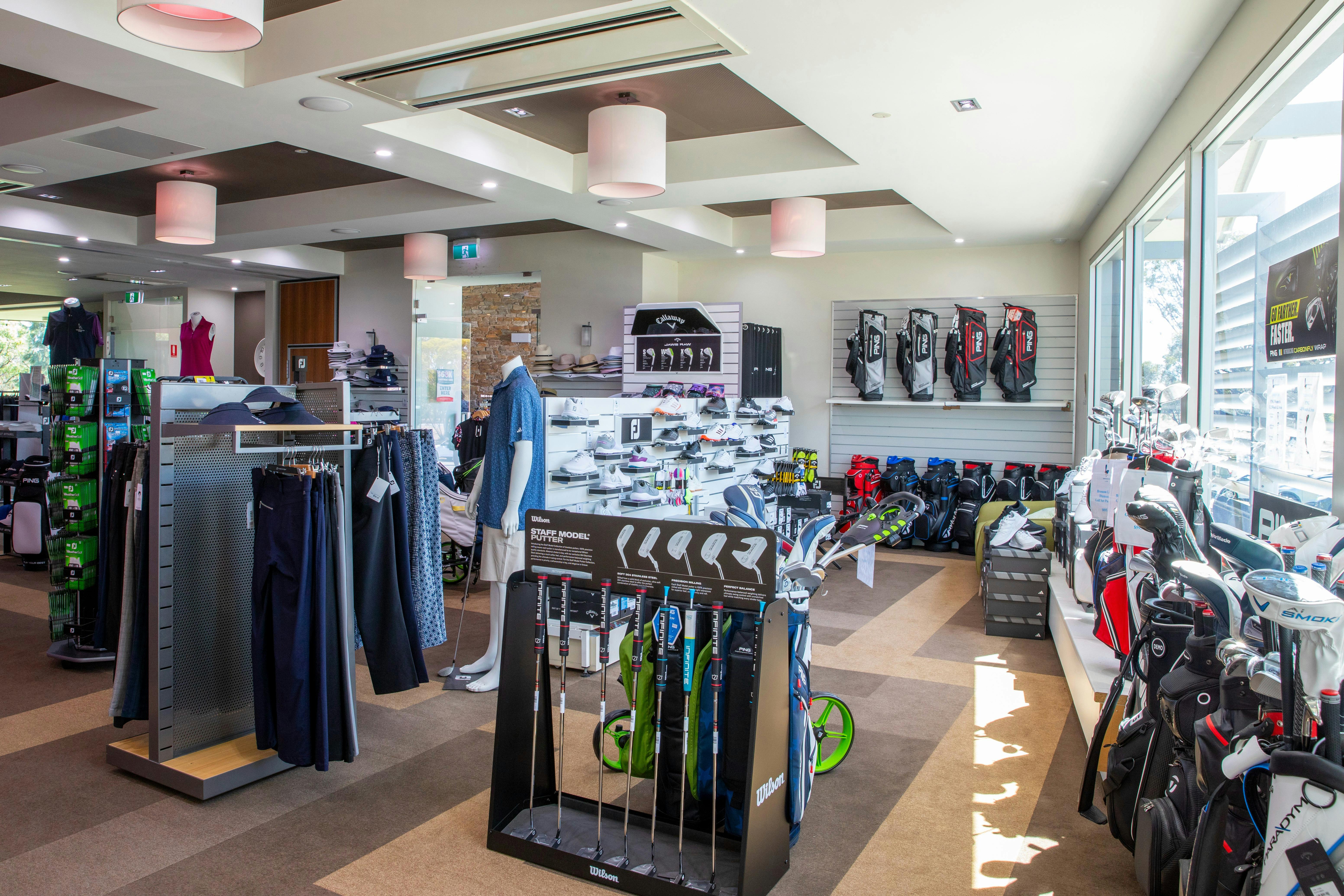 Inside of a golf pro shop with racks of clothes and accessories for golf
