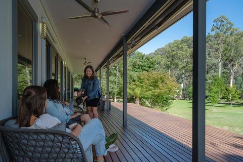 Guests enjoying wine on the veranda of the Hume House Merrijig