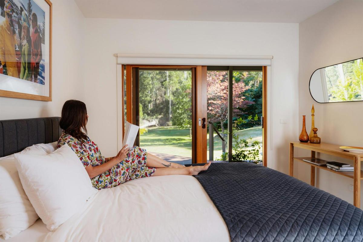 Guest relaxing in the bedroom of the Hume House Merrijig