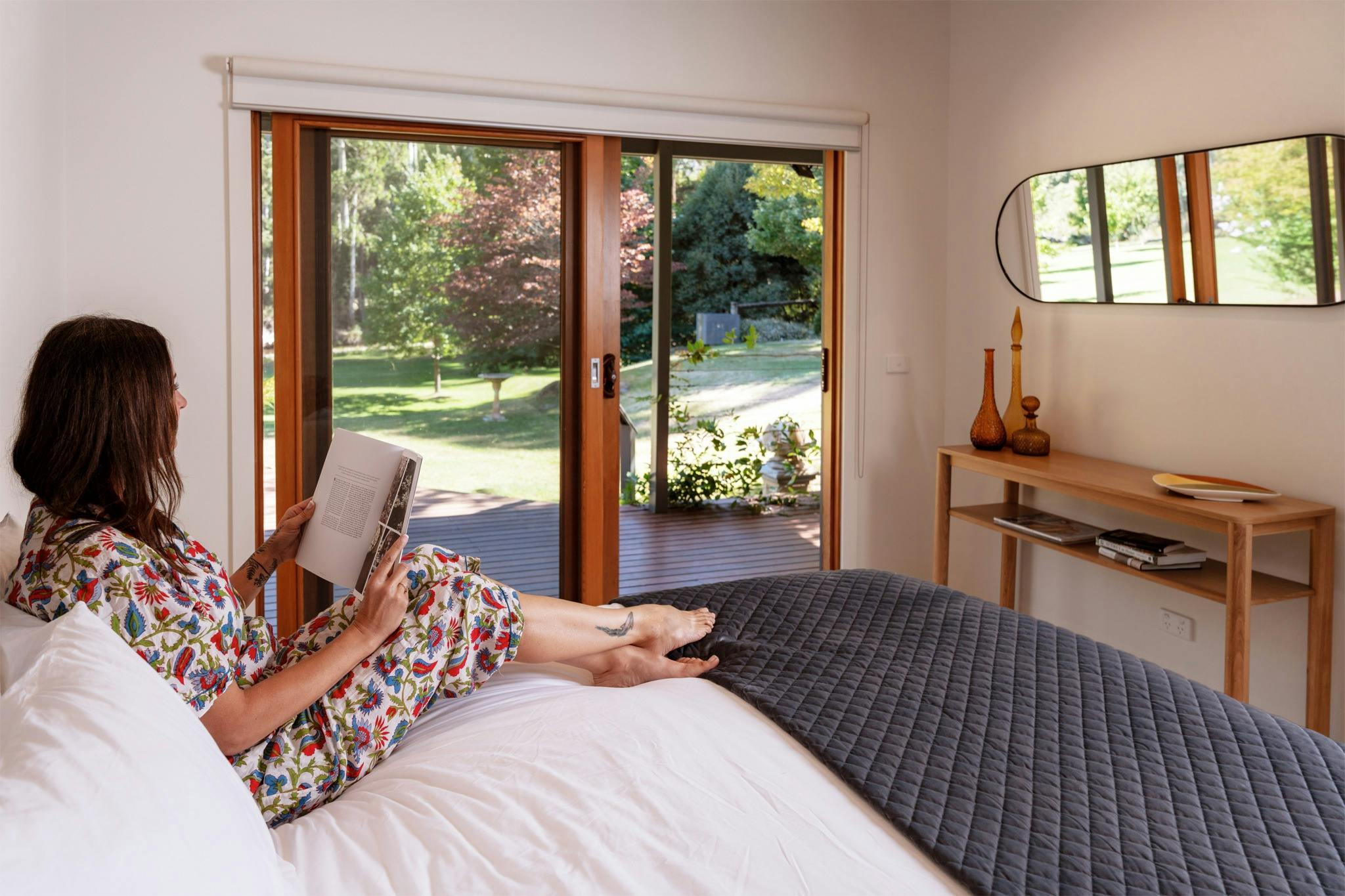 Guest relaxing on bed at Hume House Merrijig