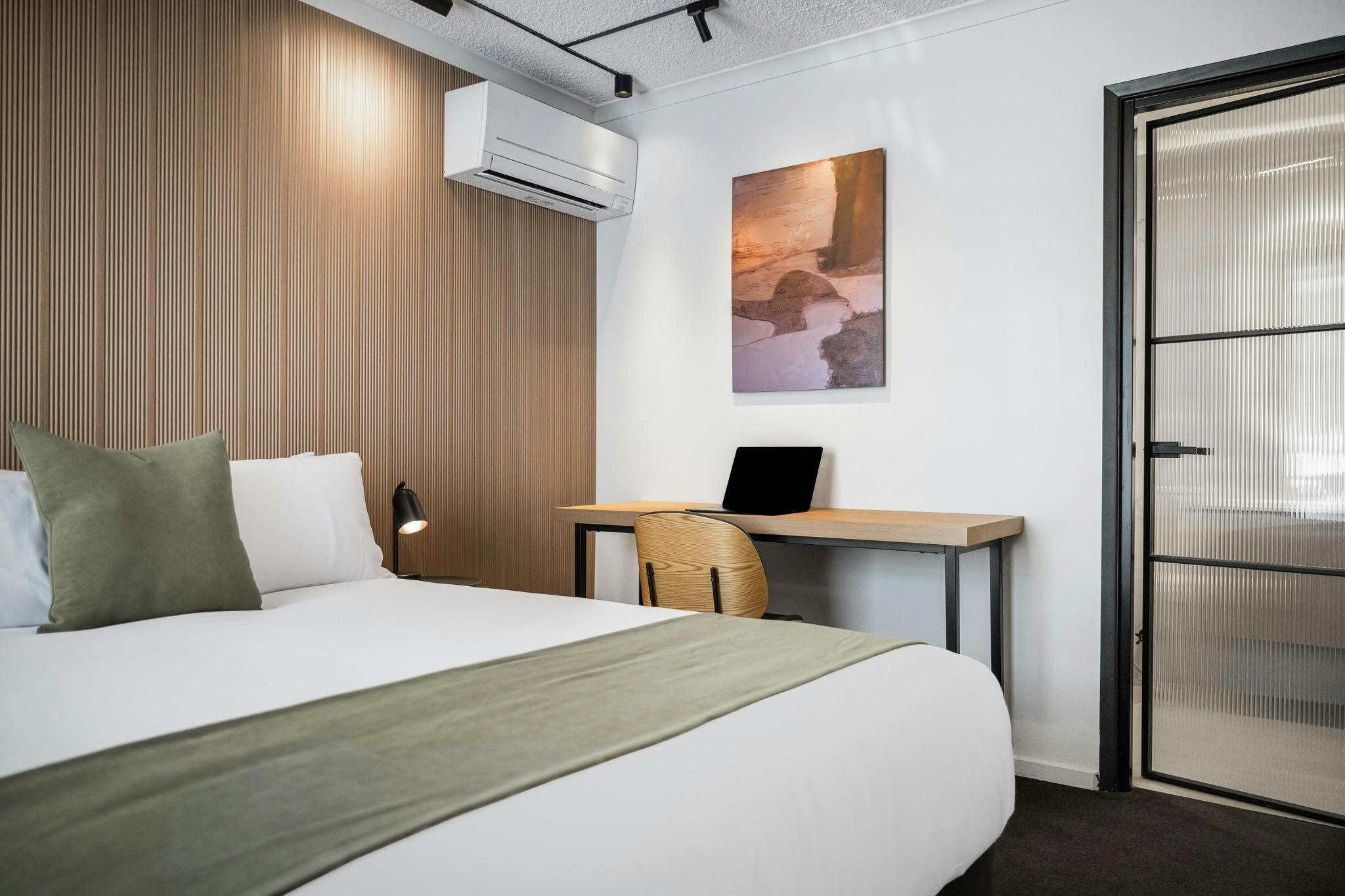 A queen sized room with a bed and desk