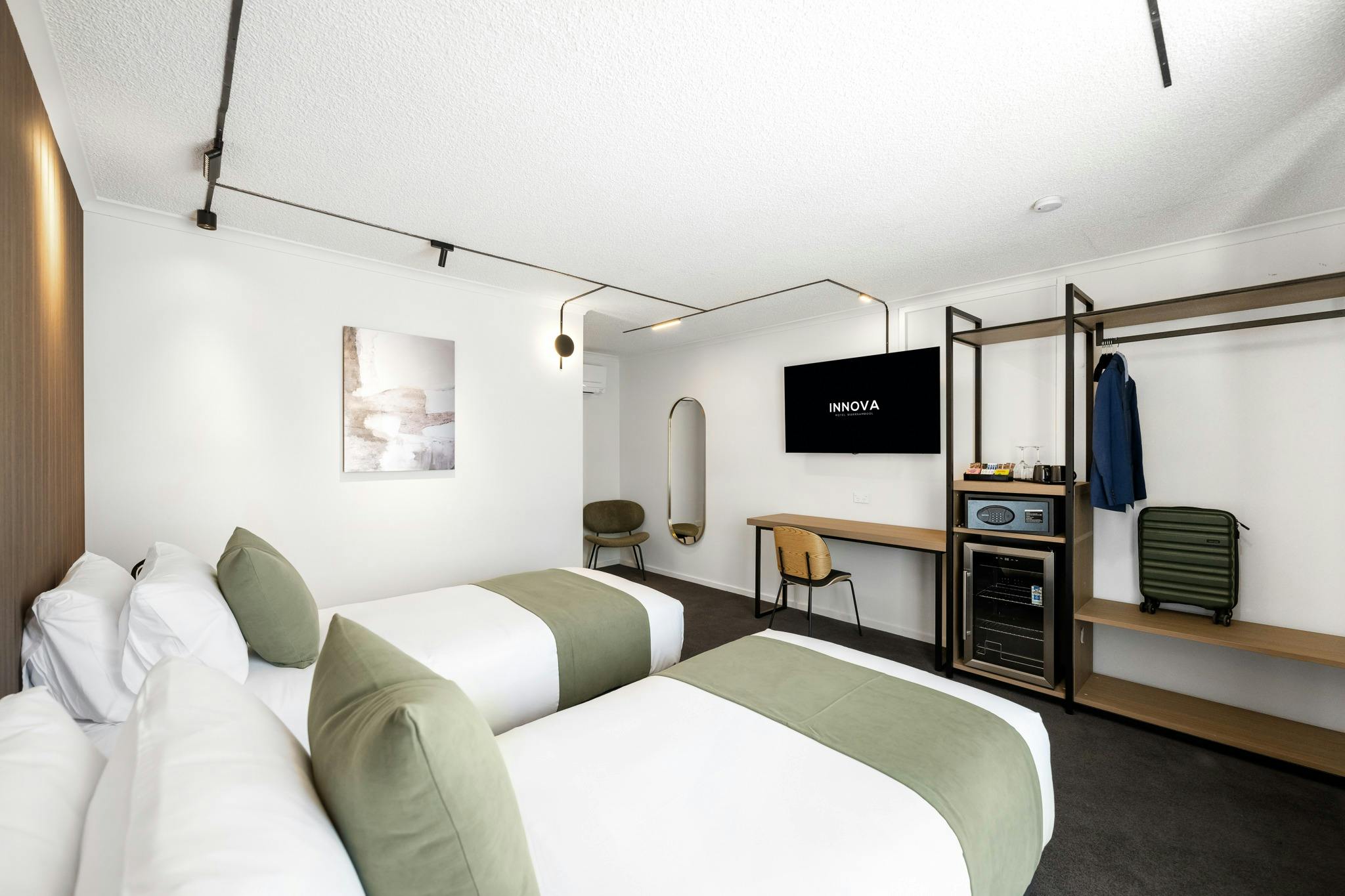 Twin room with two twin beds, a desk and television above