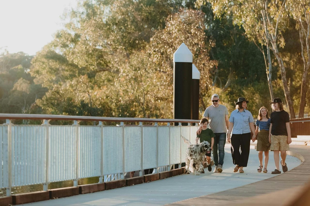 Family walking their dog along the boardwalk at Albury Riverside Precinct.