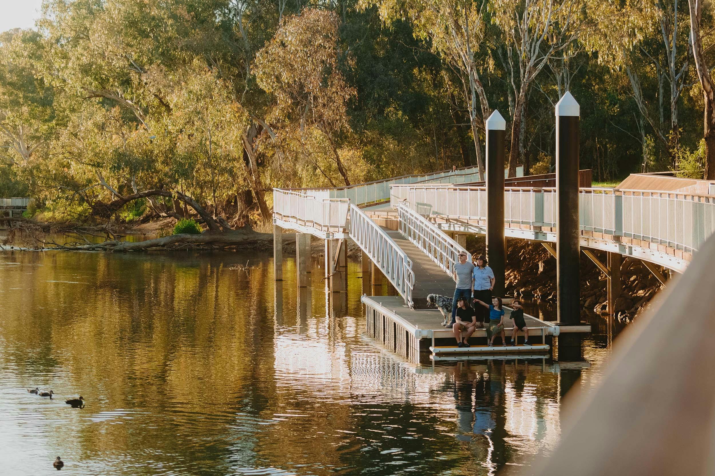 Family sitting on floating dock at the Albury Riverside Precinct