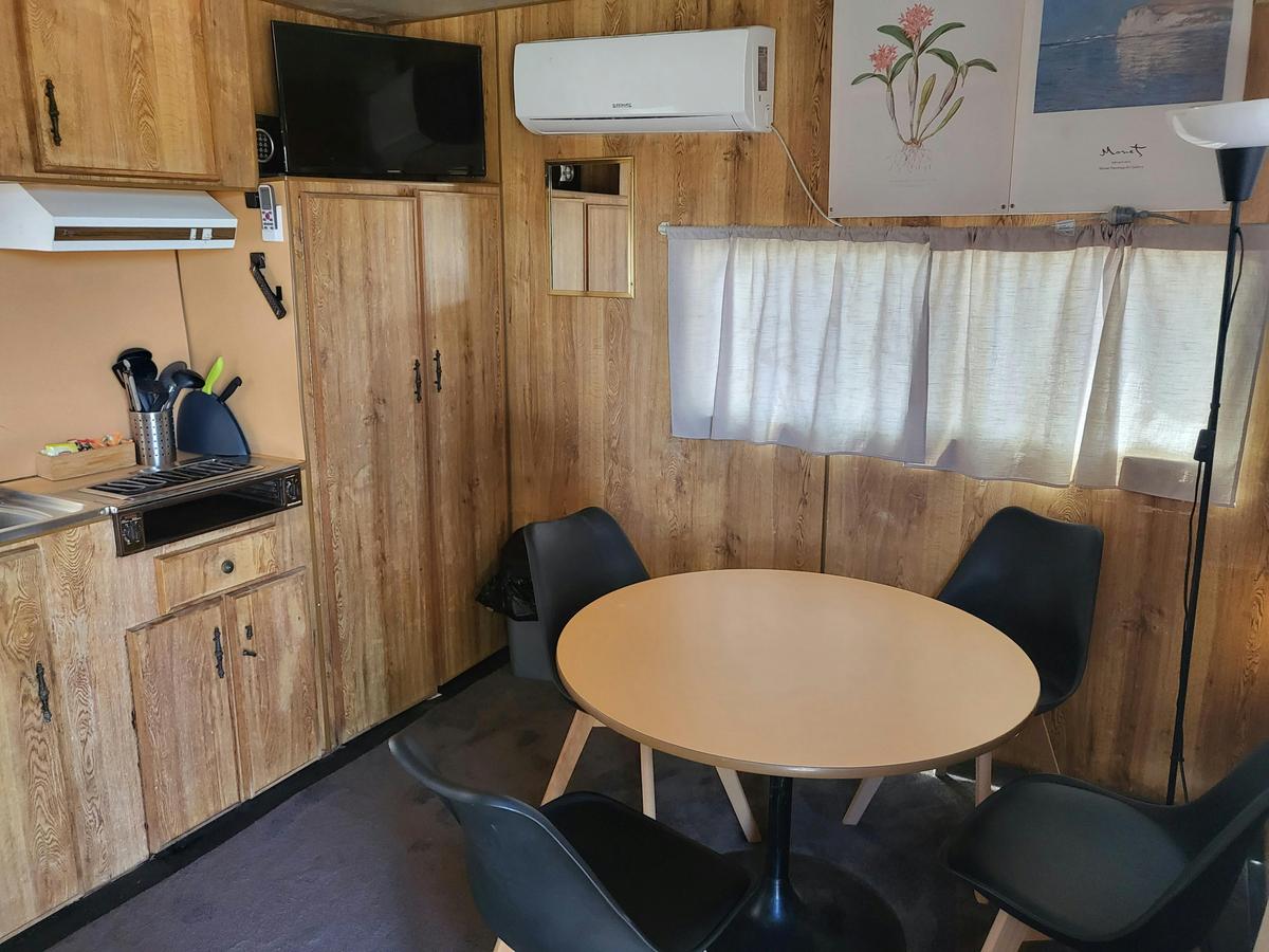 Dining area table and comfortable chairs in a cabin at Kangaroo Lake Hotel Motel Accommodation
