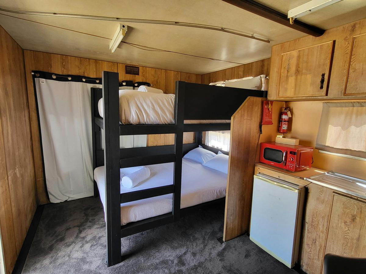 The warm, wooden interior of Cabin 4, complete with a comfortable bunk bed