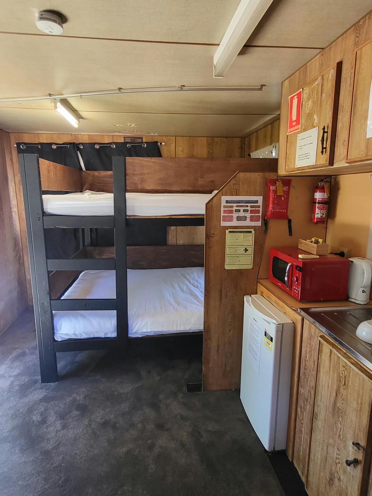 Cozy cabin interior with bunk beds and a kitchenette at Kangaroo Lake Hotel Motel