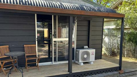Black Cabin 8 with outdoor seating and a compact air conditioning at Kangaroo Lake Hotel Motel