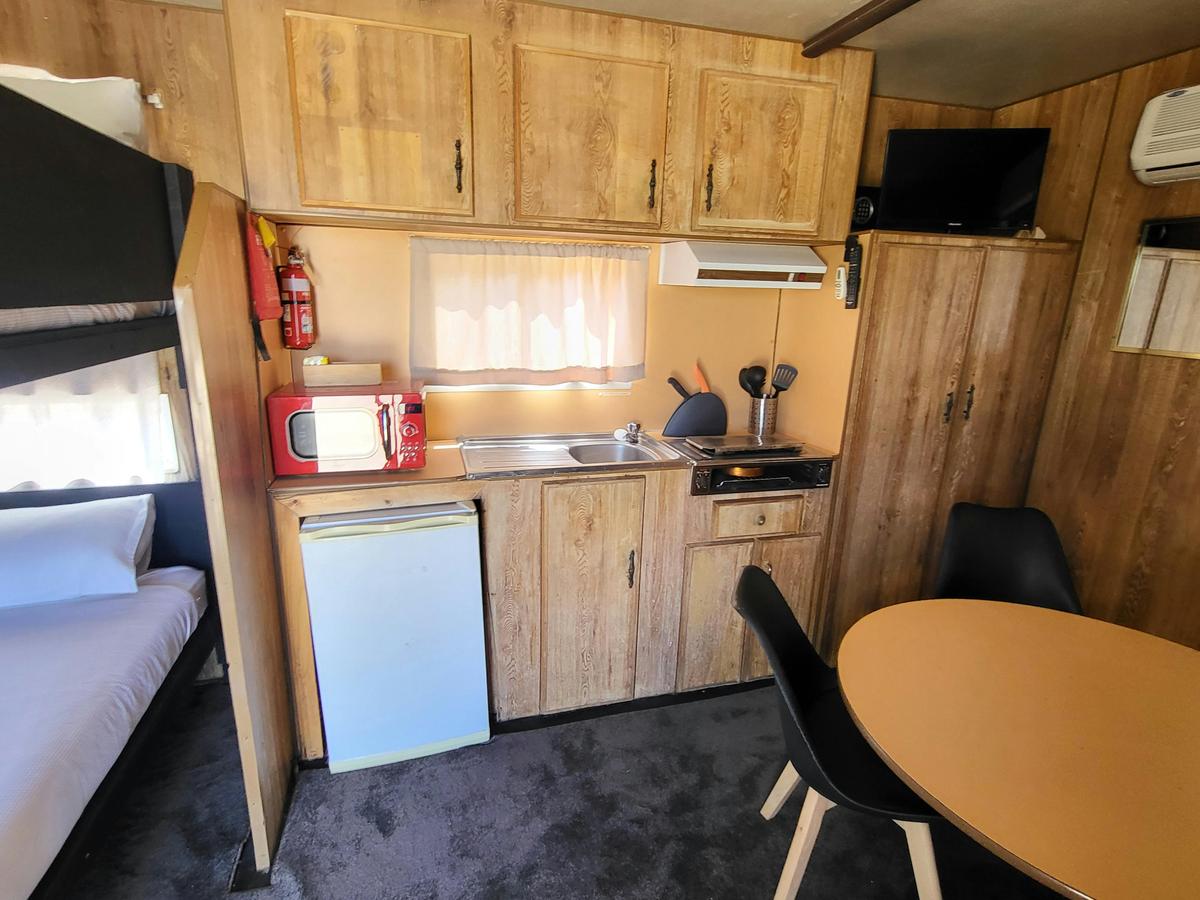 Kitchen area in Cabin 4 featuring a microwave, sink, and wooden cabinets