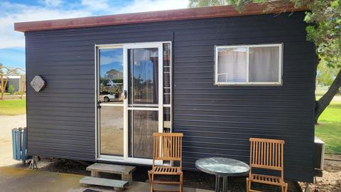 Charming black cabin exterior with outdoor seating at Kangaroo Lake Hotel Motel accommodation
