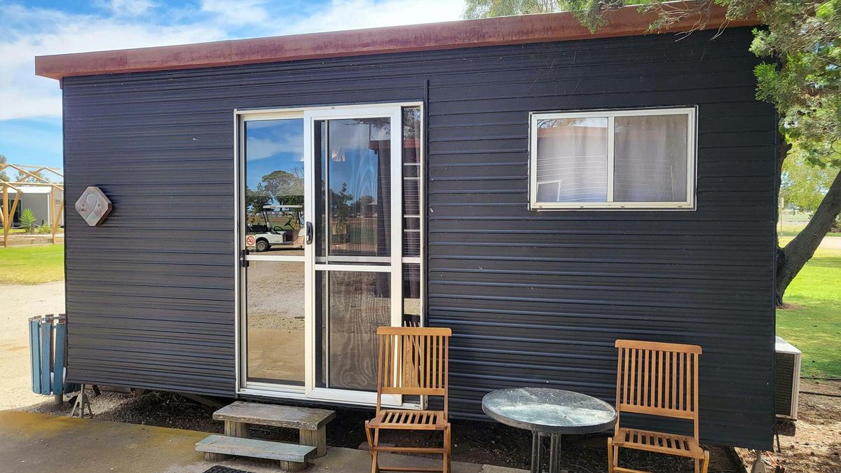 Charming black cabin exterior with outdoor seating at Kangaroo Lake Hotel Motel accommodation