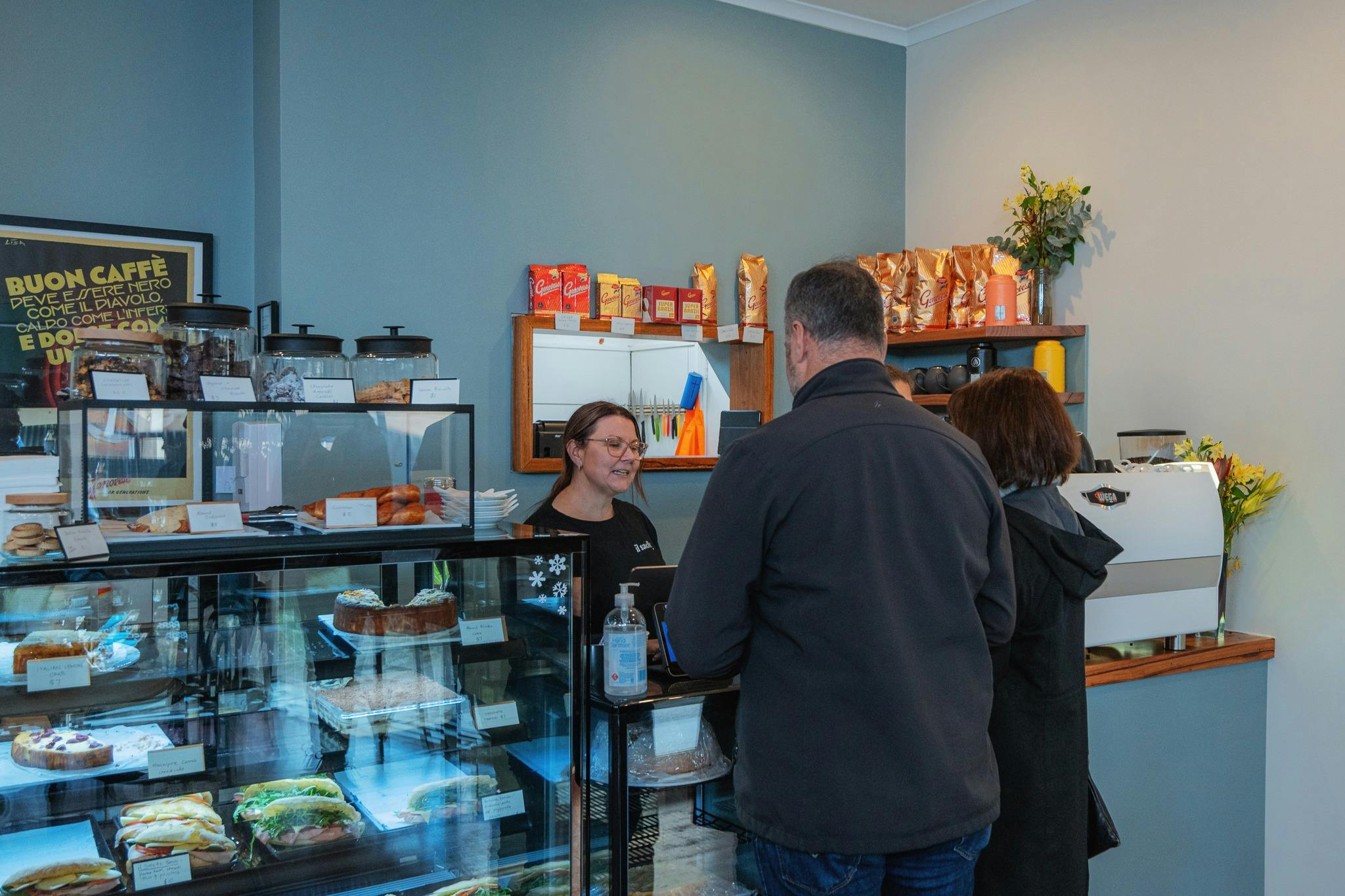 Person standing at the counter with food display cabinet