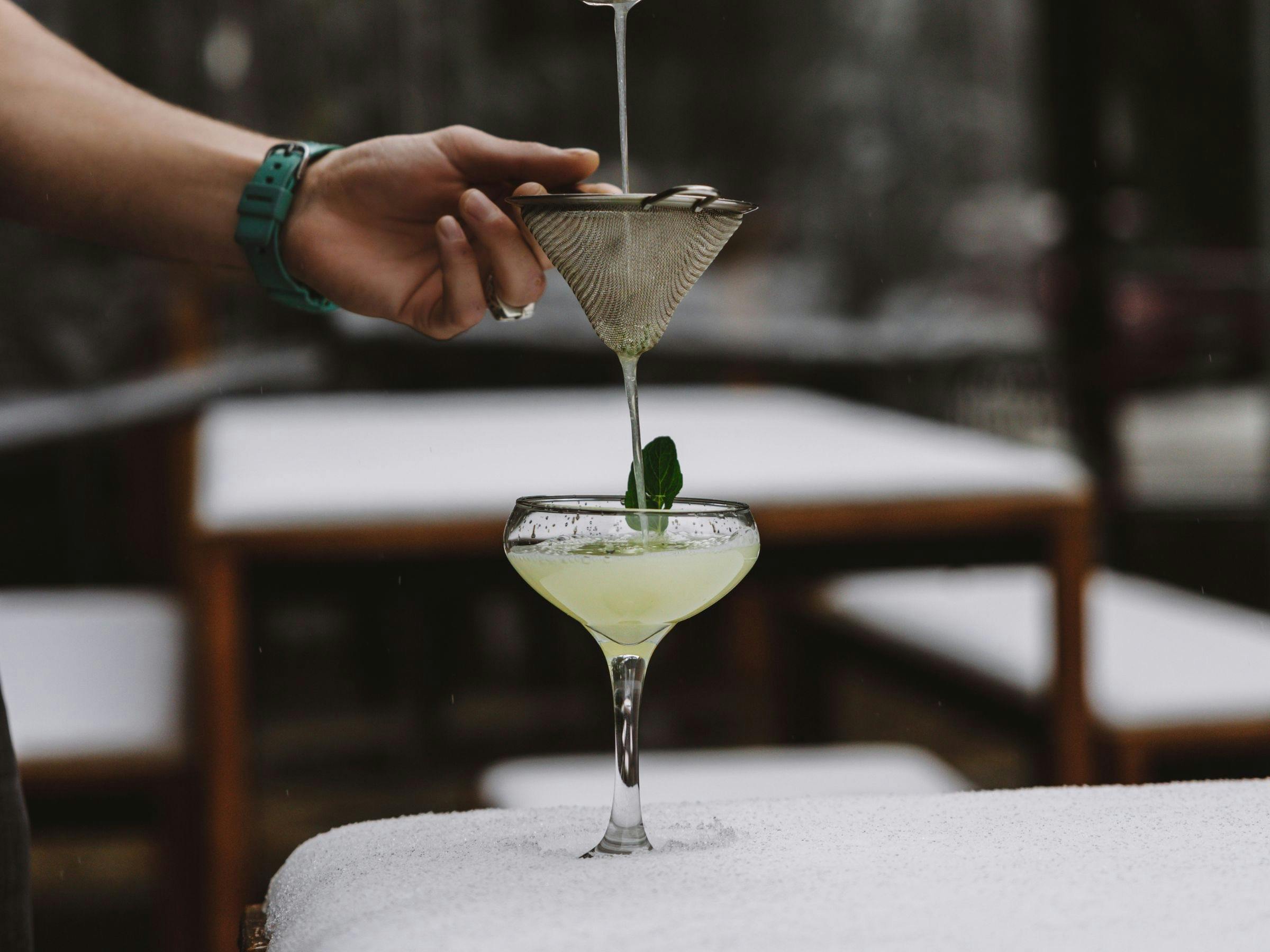 A cocktail being poured outside in the snow
