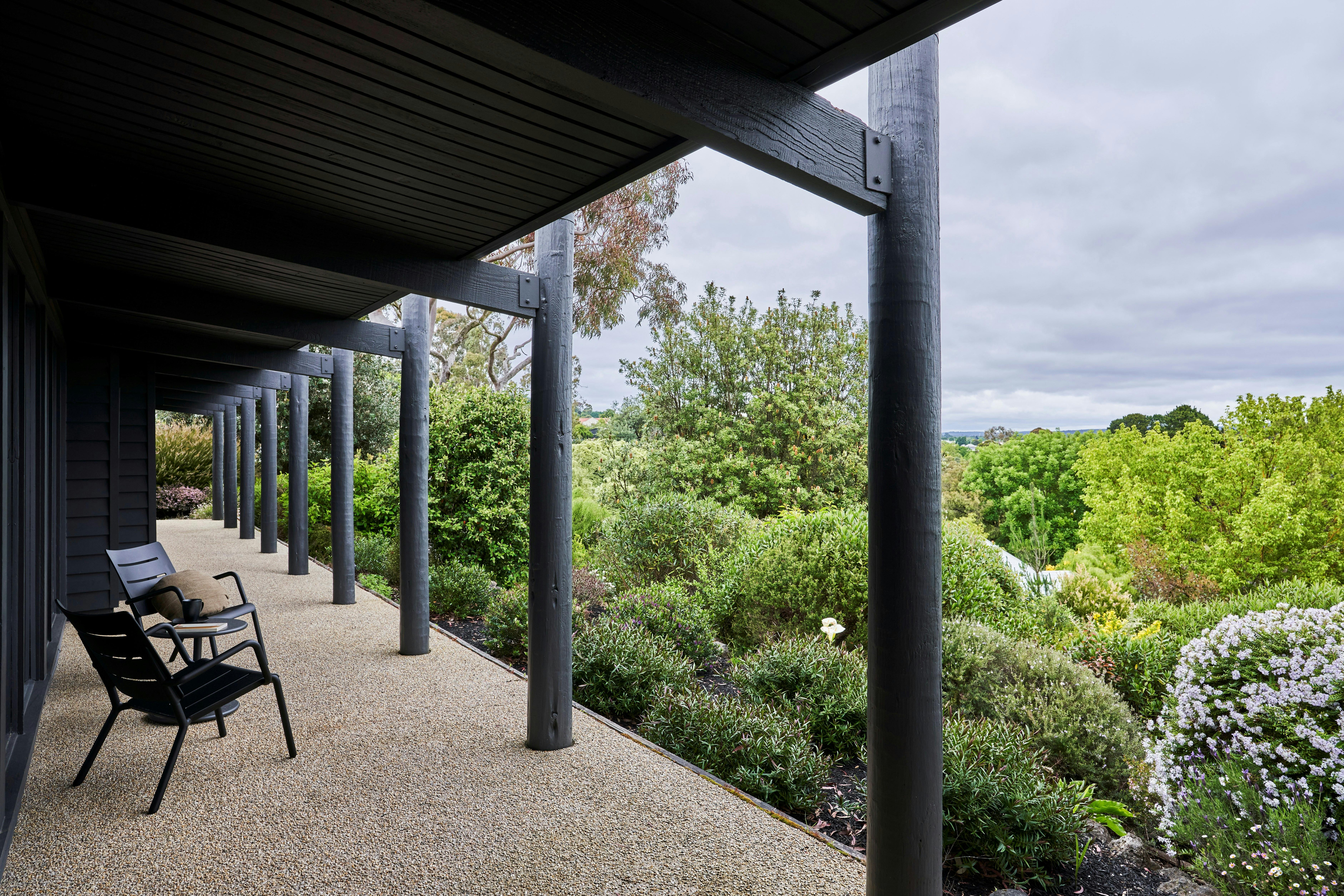 Jumoku Verandah with black chairs looking out onto the green bushes in the garden