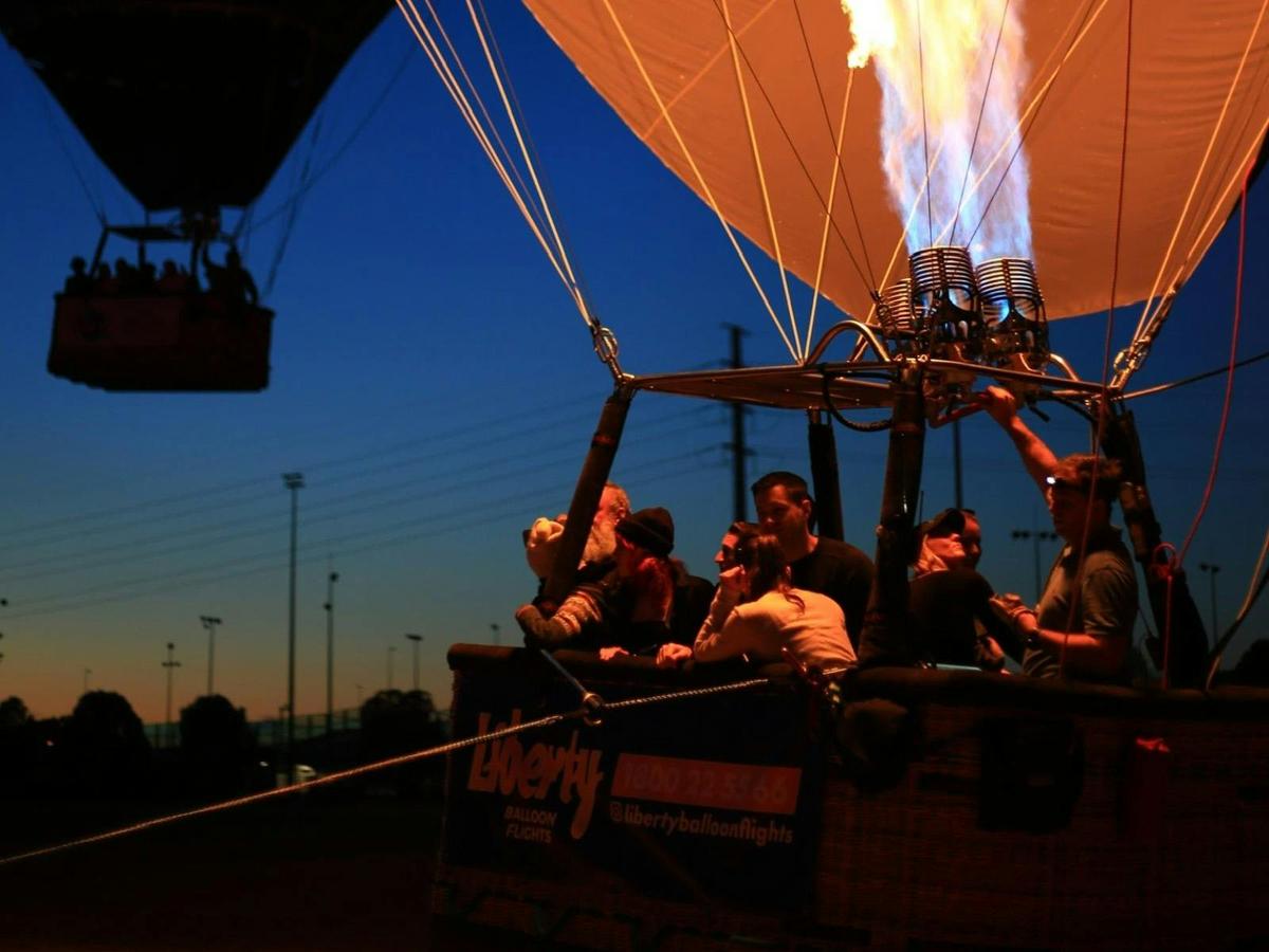 Passengers about to embark on a hot air balloon flight with the balloon ready for launch