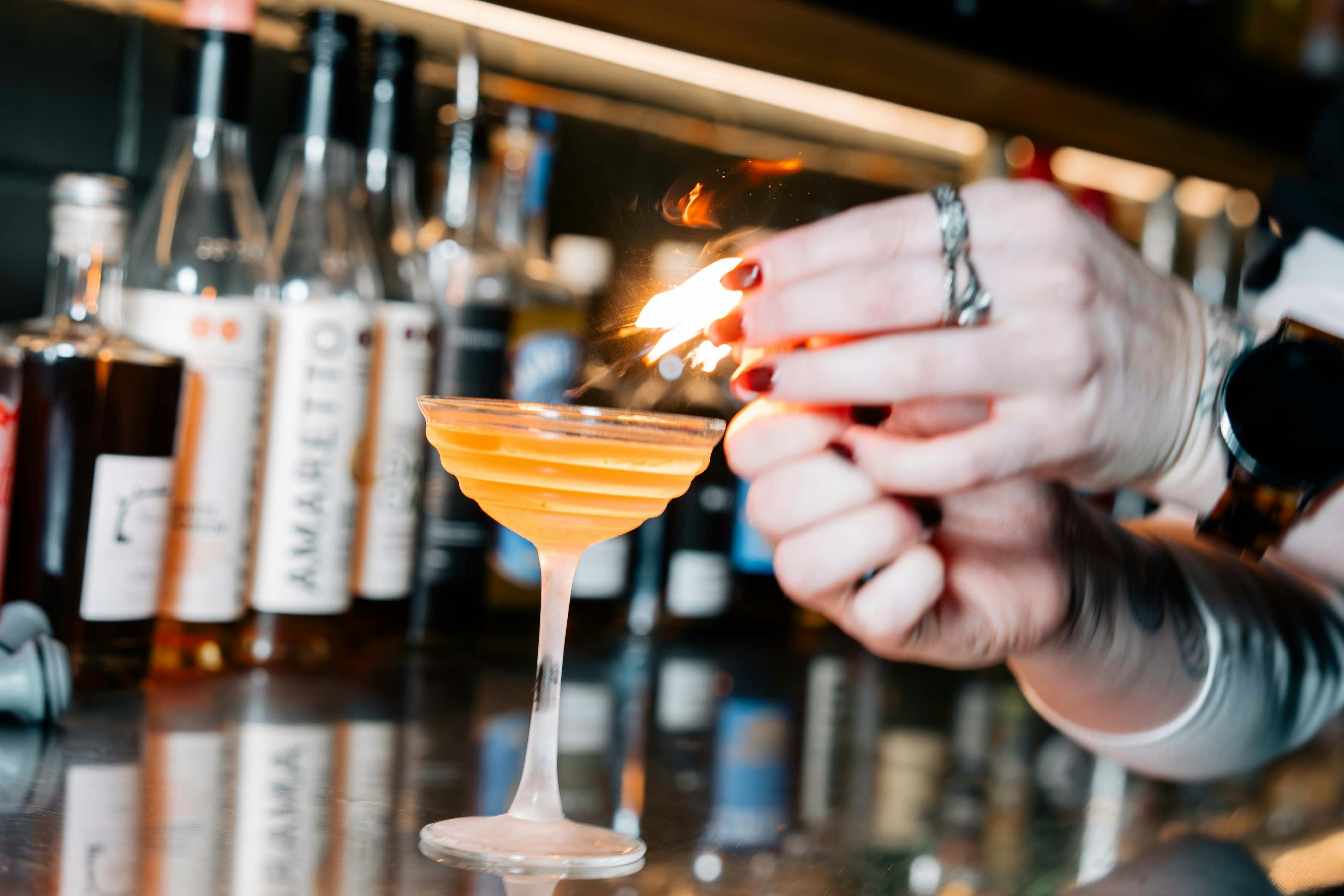 Citrus on fire garnishing cocktail