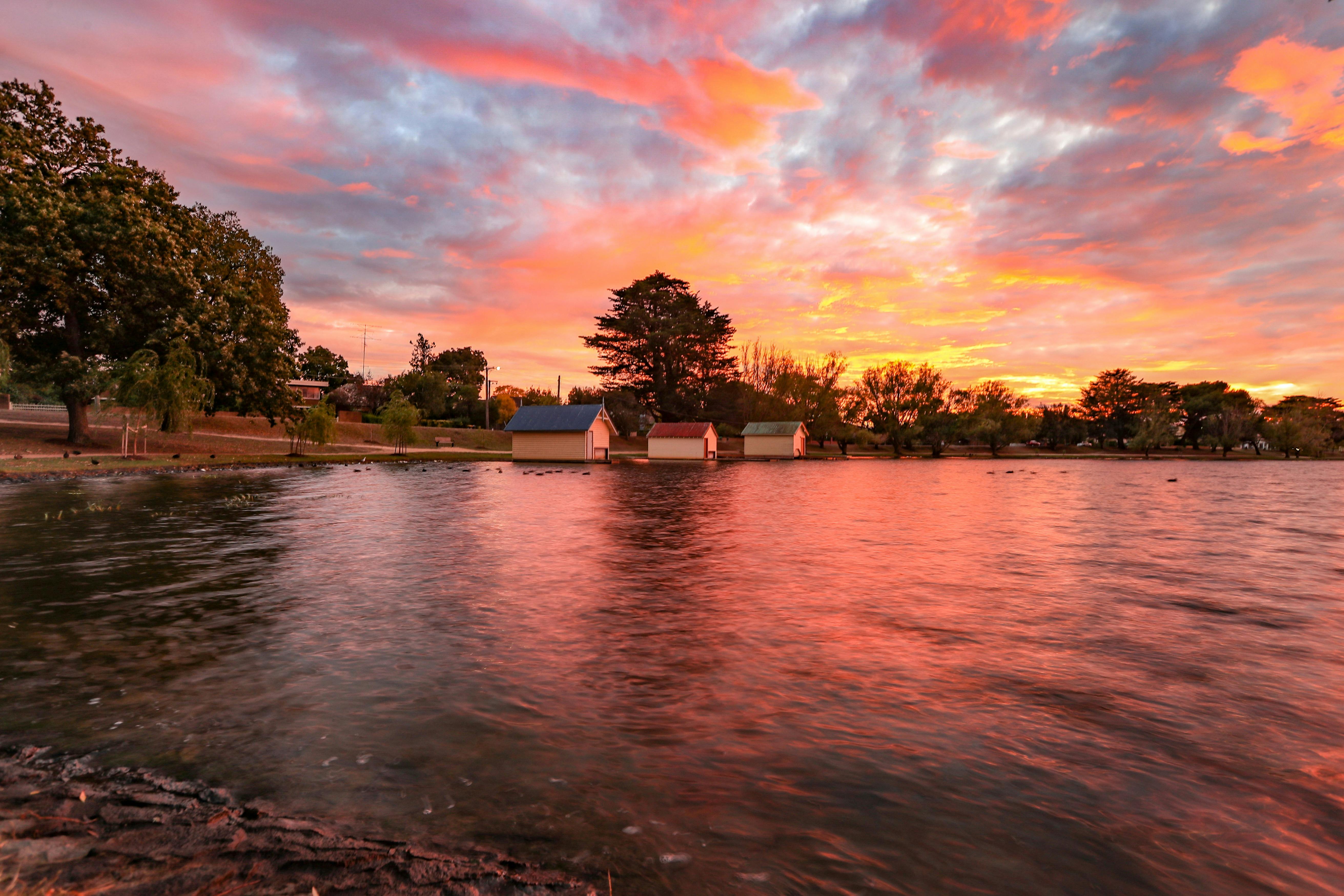 lake wendouree at sunset  with pink, blue and yellow sky above and boathouses in distance