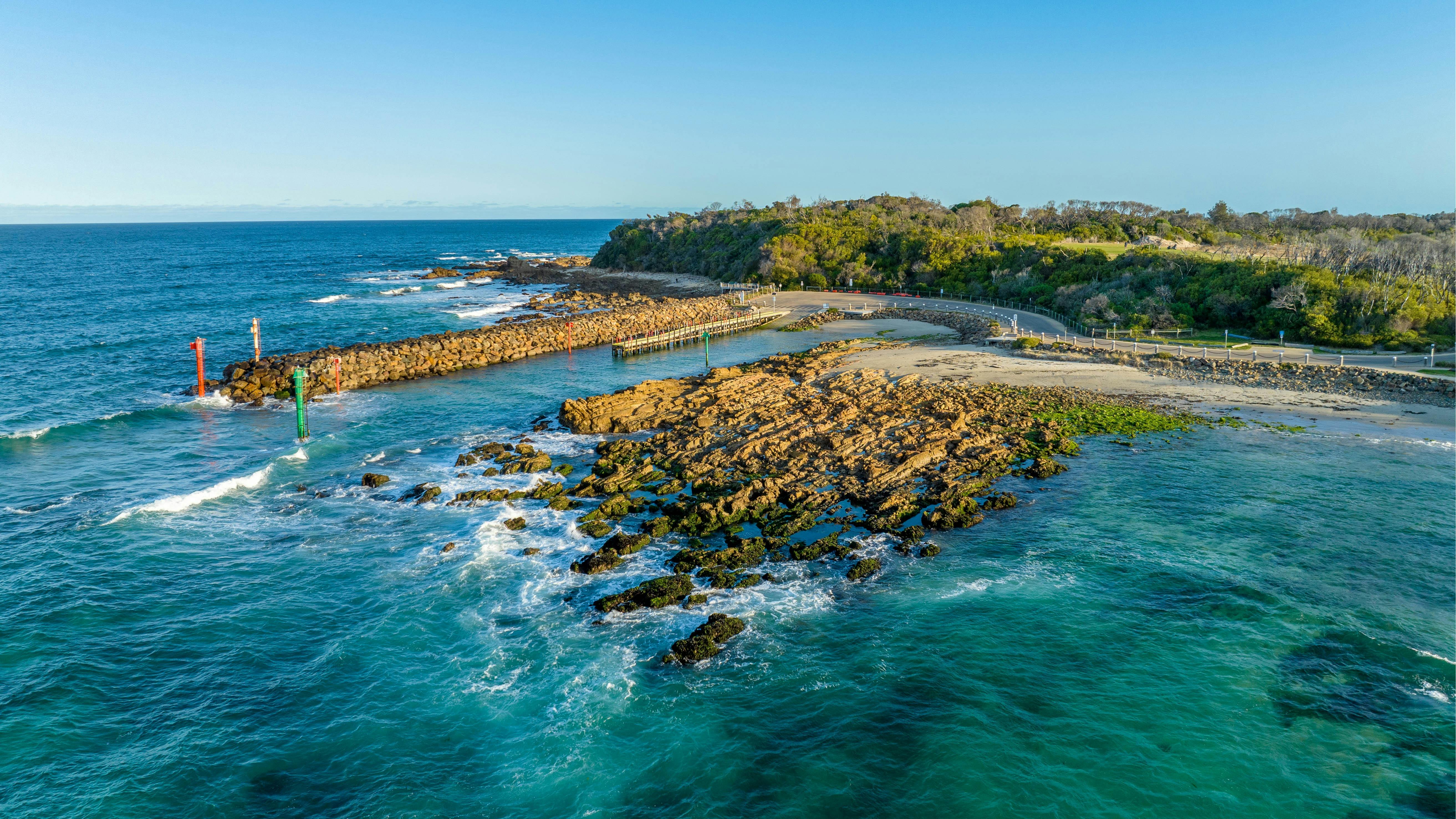 Rock wall running alongside boat ramp at Bastion Point, waves crashing on the rocks