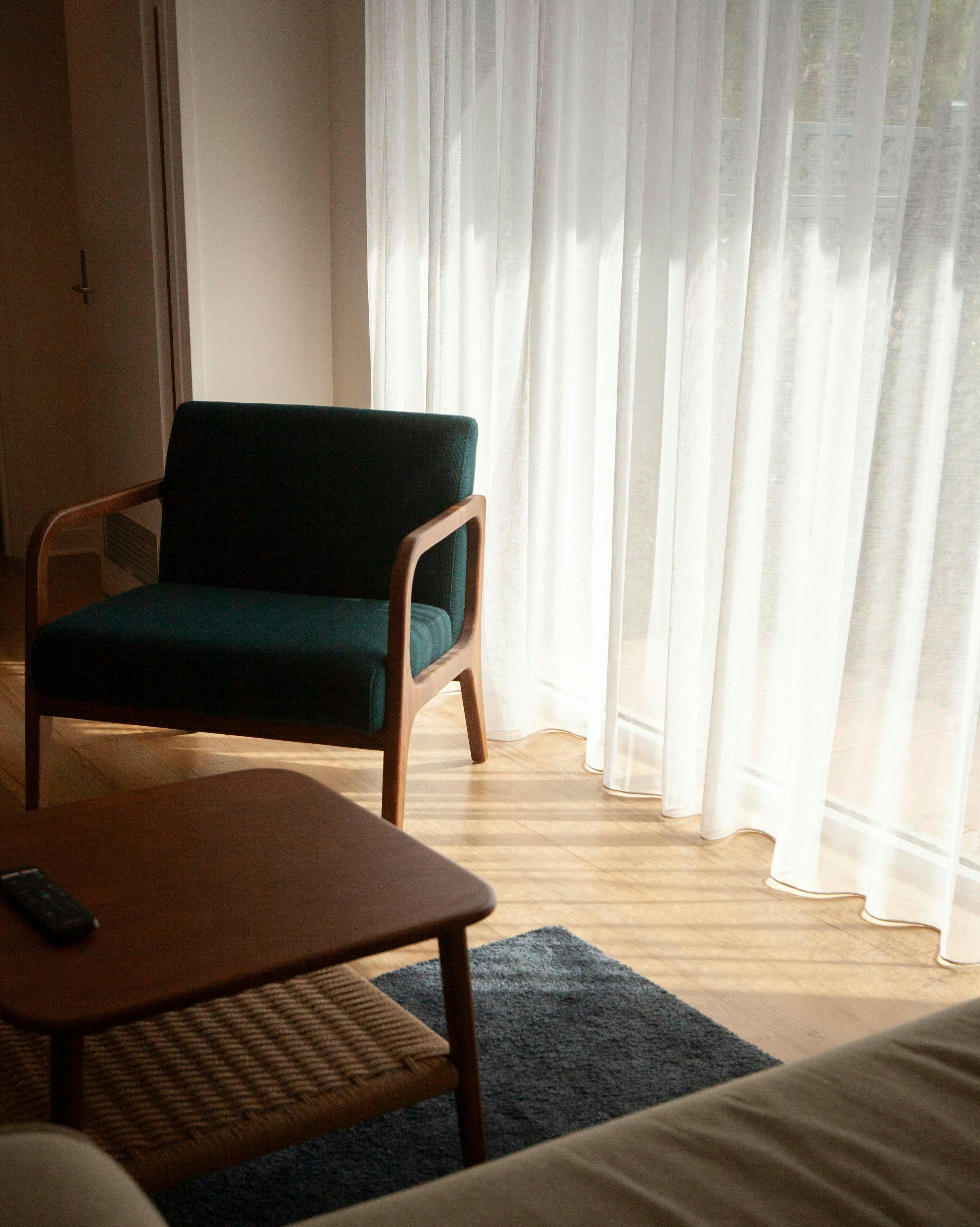 a green chair and some curtains in the background