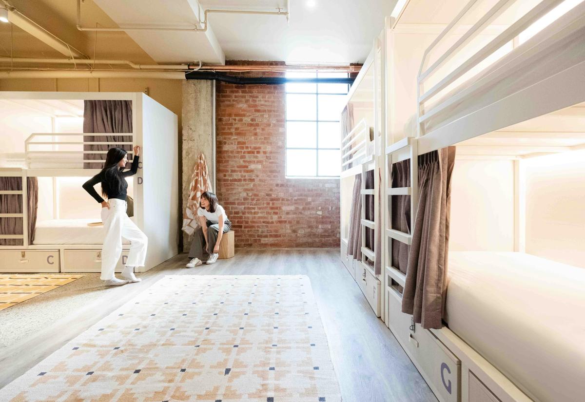 Two people chatting in a hostel dorm