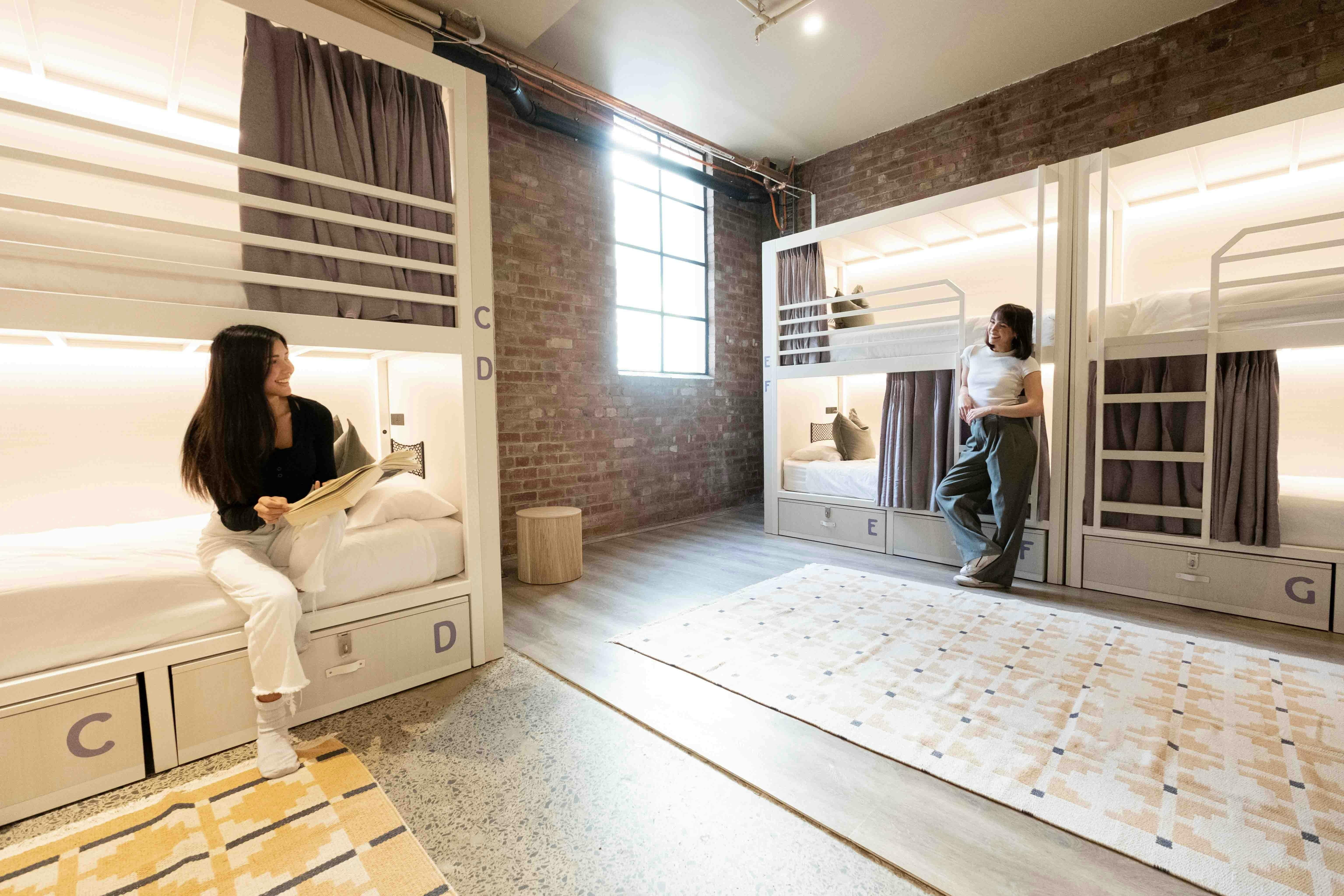 Two guests in a hostel dorm chatting