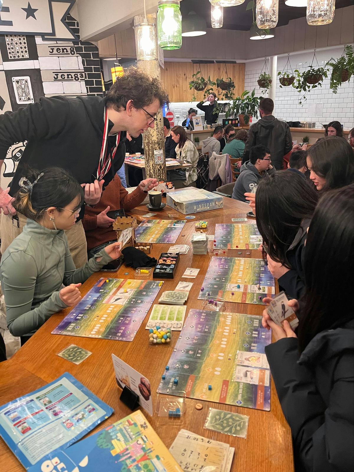 Game master Luke is showing customers how to play Wingspan.