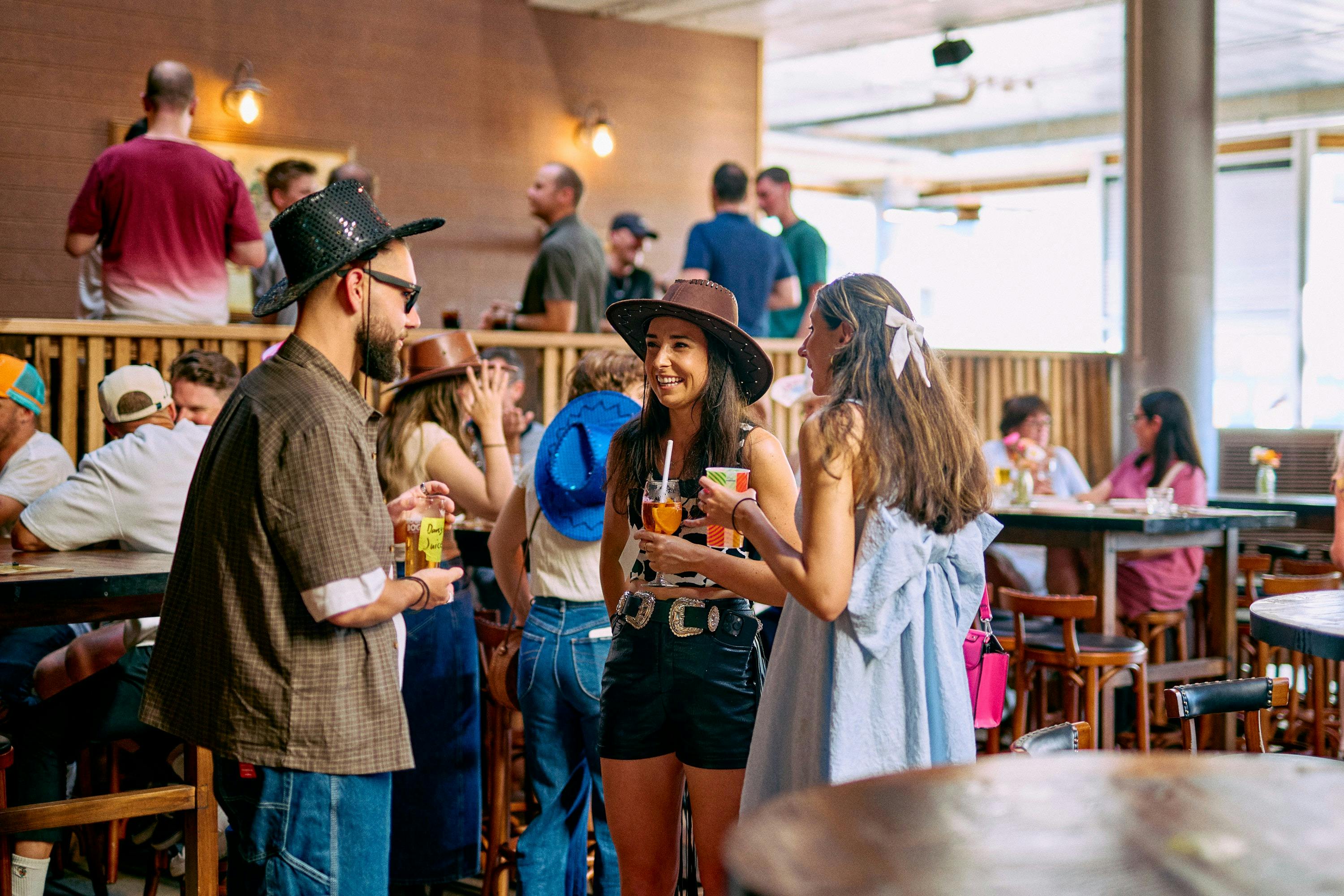 A group of people with drinks in hand enjoying the vibes at Moon Dog Wild West