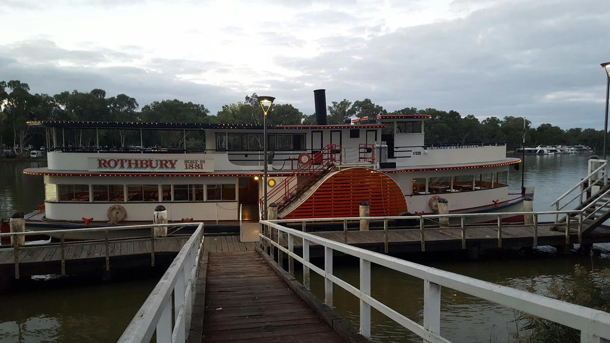 The flood lights from the Paddle Vessel Rothbury light up the riverbanks.