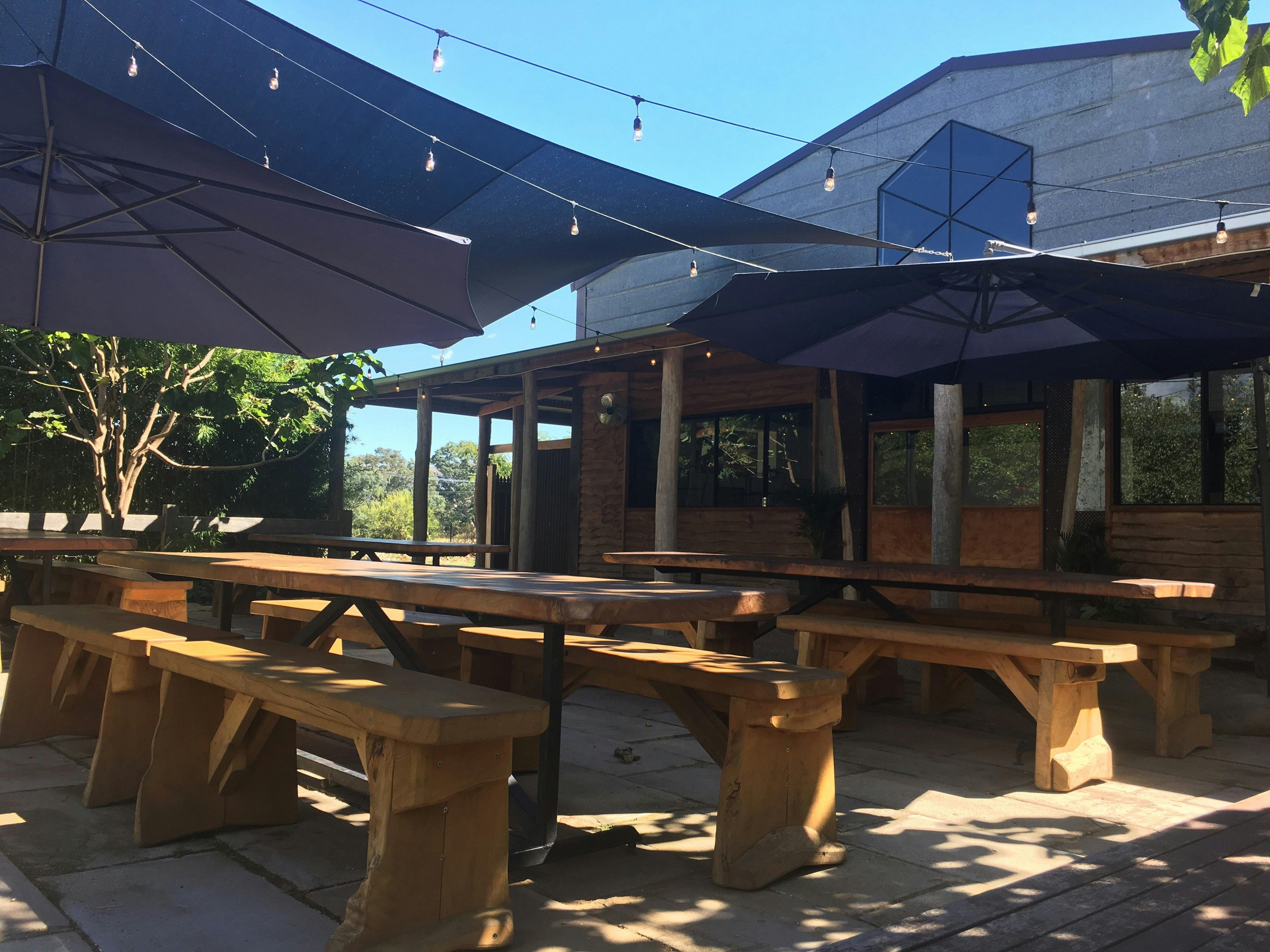 The shady beer garden featuring hand crafted furniture from local timbers.
